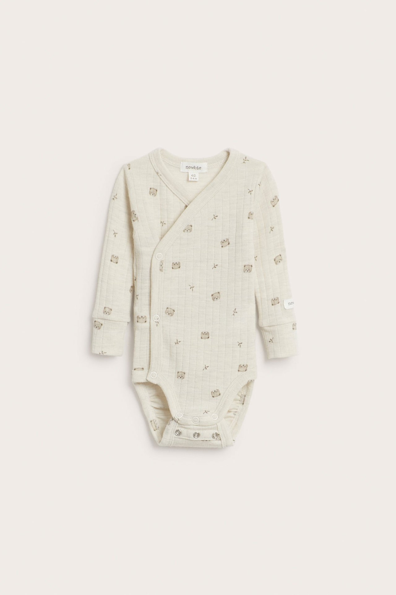 Frontbilde av en lys beige vattert babyomslagsbody med små dyremønstre.