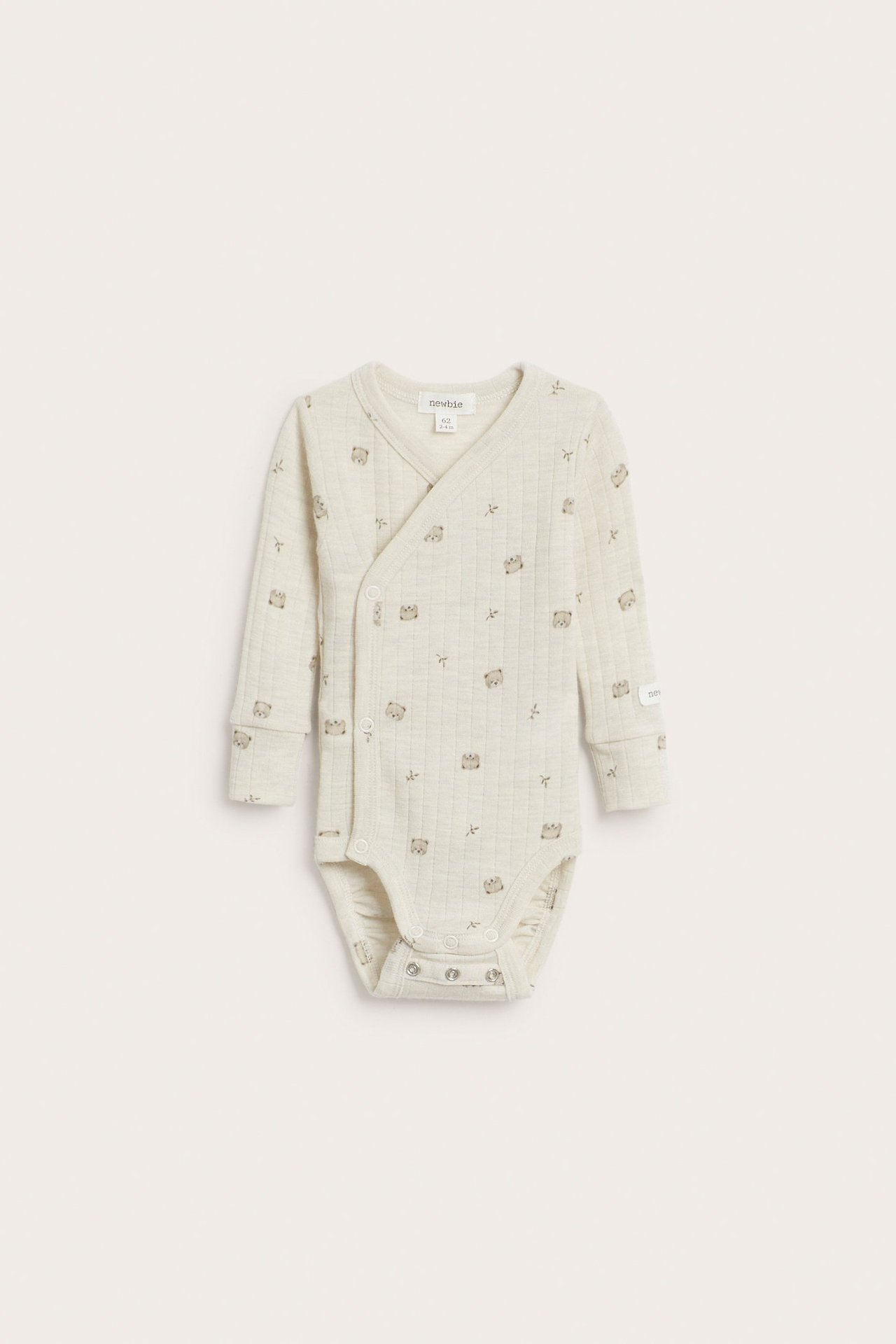 Framifrån: beige melerad ribbad babybody i merinoull med djurmönster och tryckknappar.