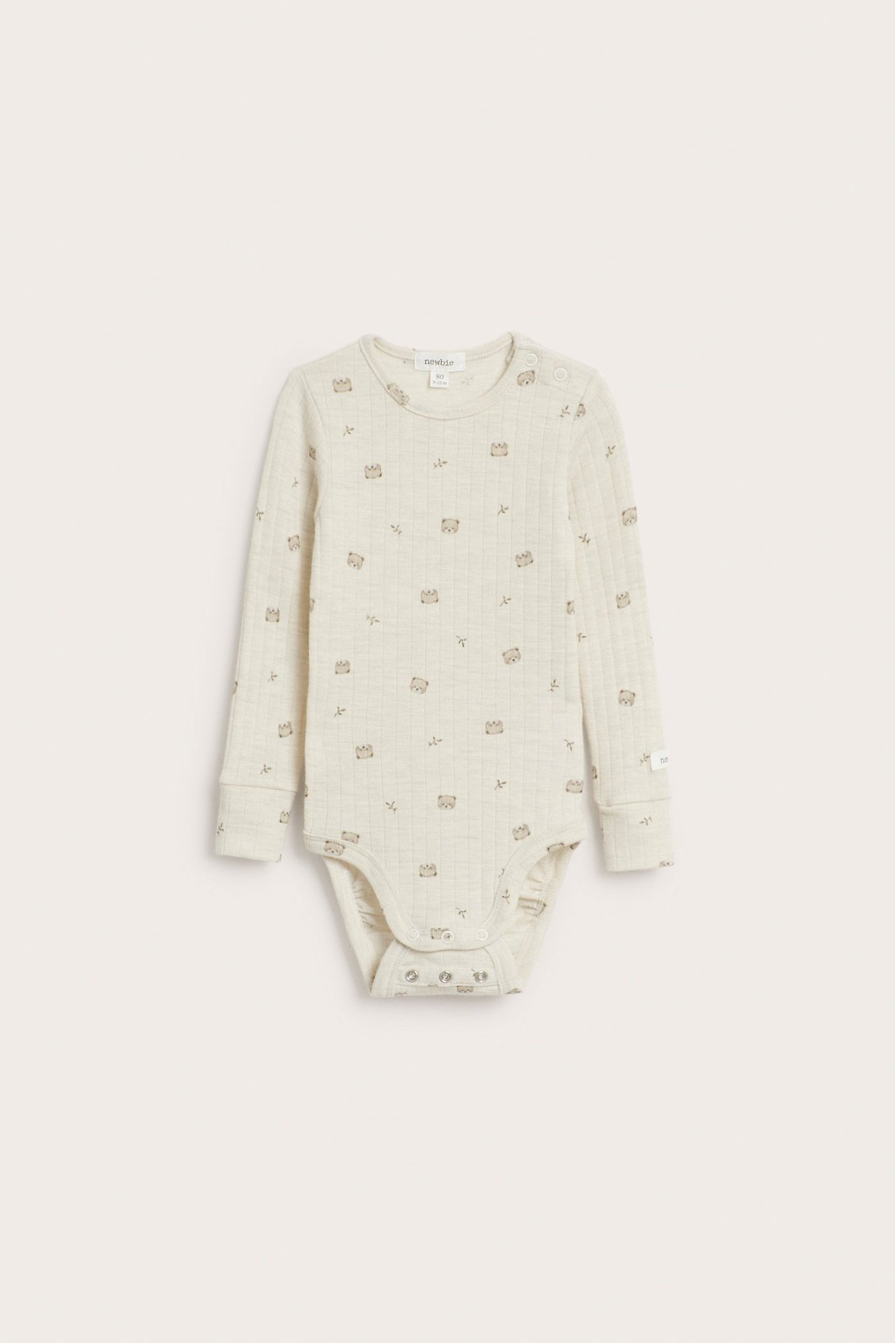 Framsida: beige melerad ribbad långärmad babybody i ull med diskret djurmönster, tryckknappar.