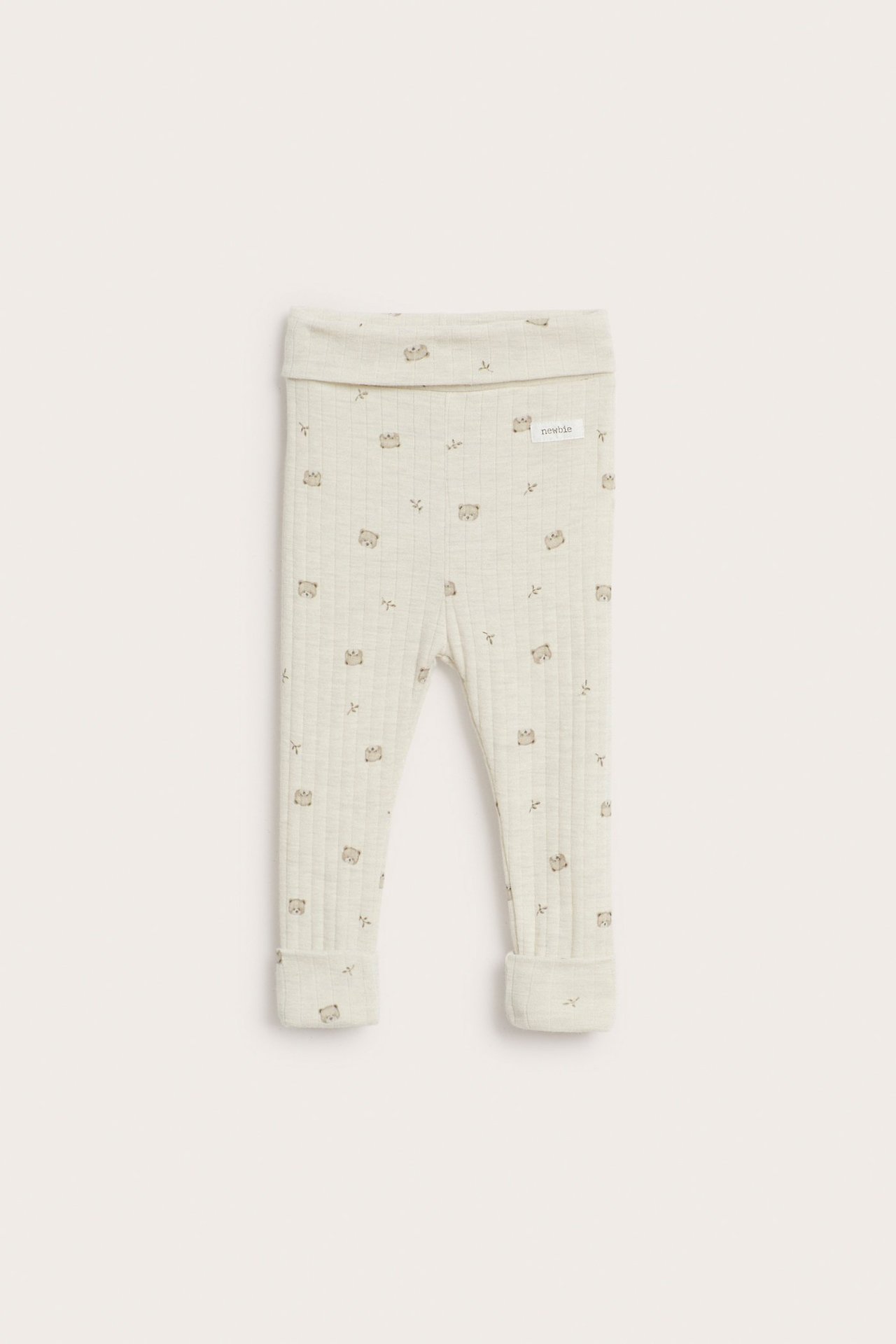 Frontvy av beige melange ribbade leggings i merinoull för baby med diskret djurmönster och uppvikbara muddar.