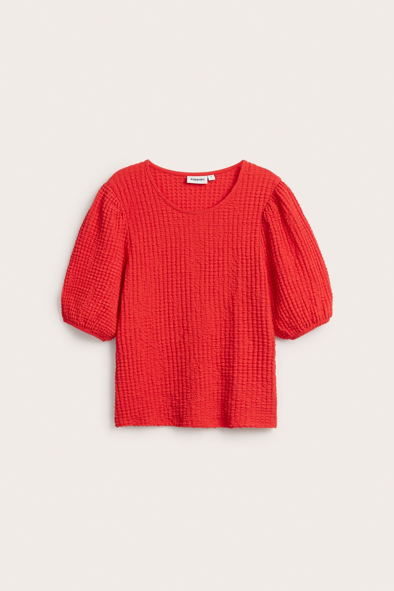Widok z przodu czerwonego topu o strukturalnej tkaninie z krótkimi bufiastymi rękawami i okrągłym dekoltem.