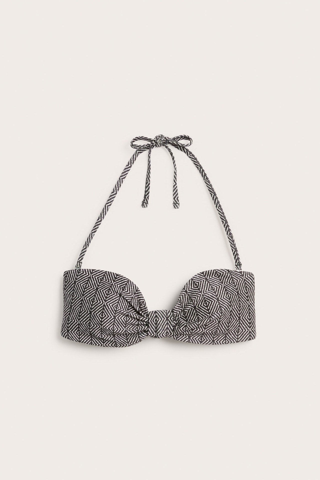 Widok z przodu czarno-białego wzorzystego biustonosza bandeau z wiązanym dekoltem halter i skręconym przodem.