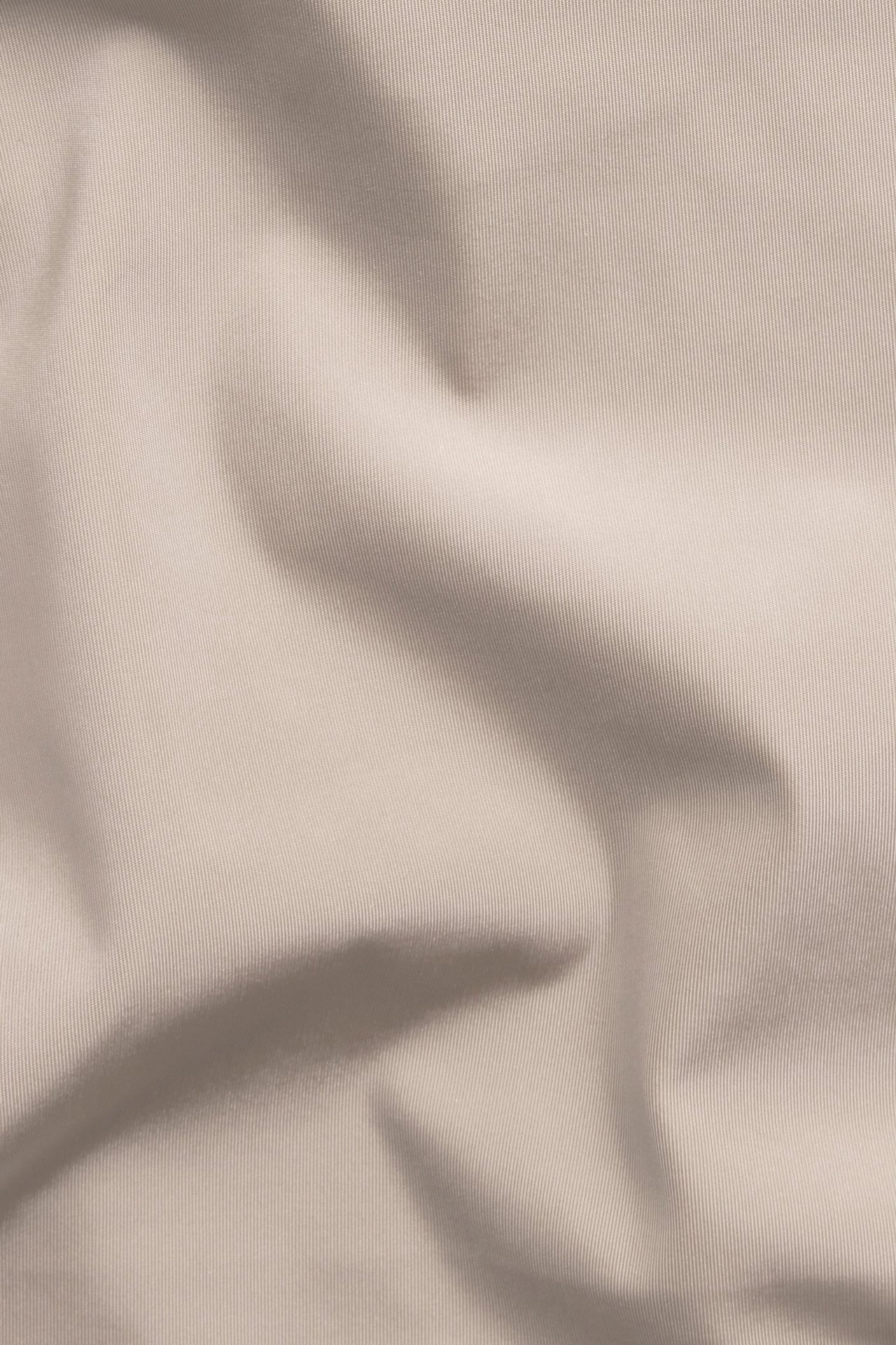 Zbliżenie różowego, jednolitego mikromateriału z miękkimi fałdami.