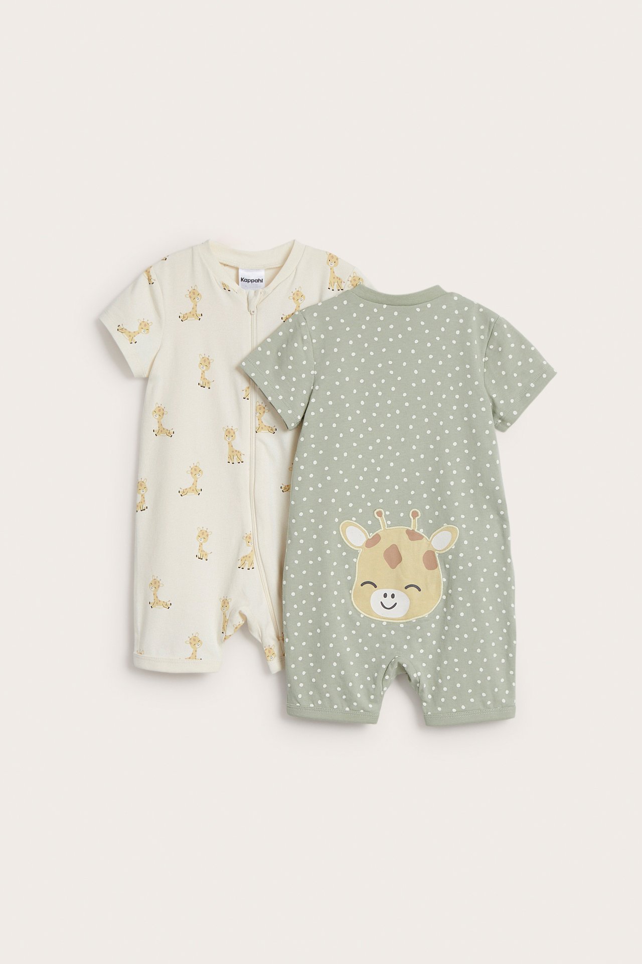 Framifrån: två kortärmade babyrompers. En offwhite med giraffmönster och dragkedja, en grön med prickar och giraffapplikation.