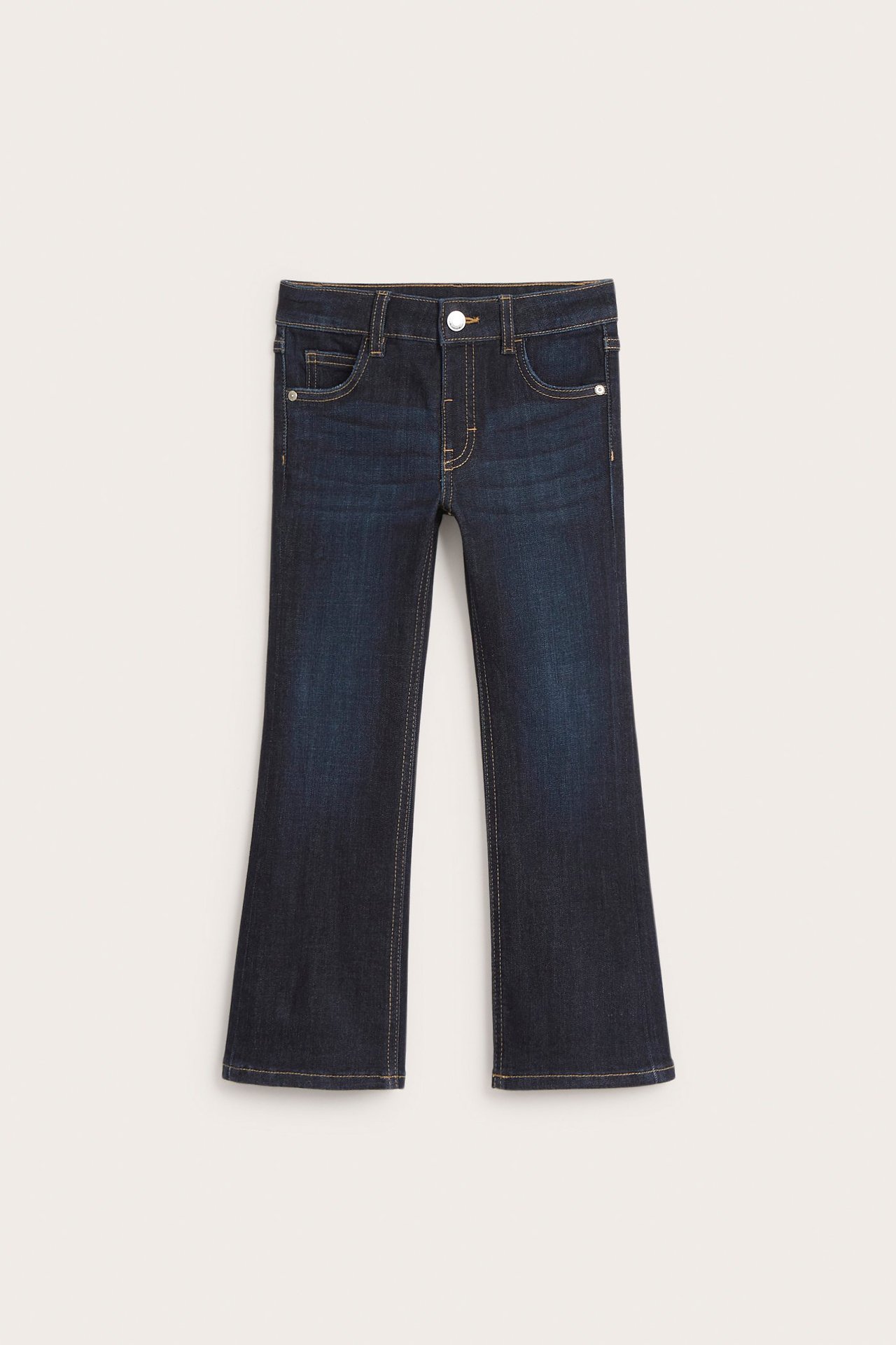 Widok z przodu ciemnych dżinsów bootcut dla dzieci, ze średnim stanem i zapięciem na zatrzask.
