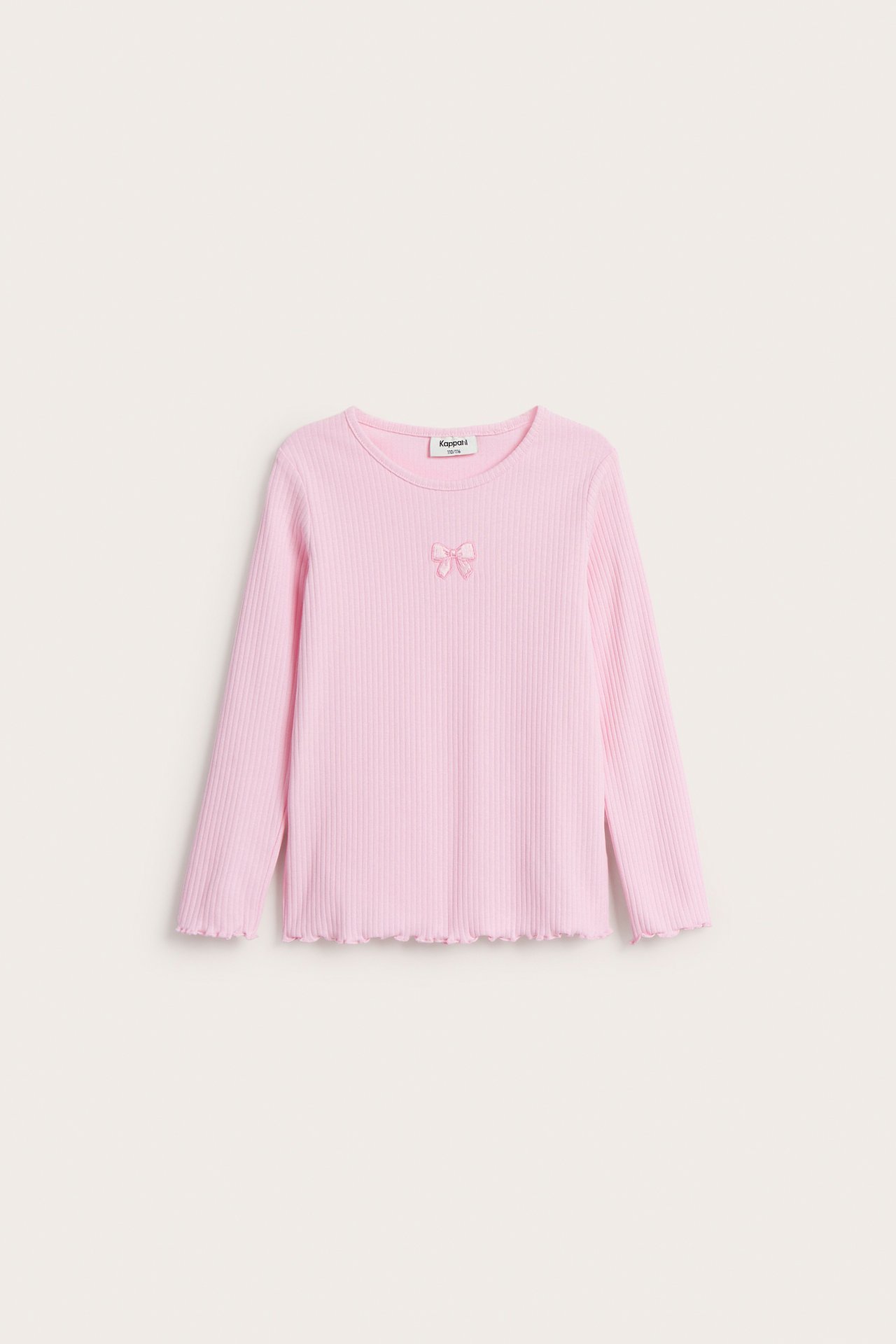 Framifrån, en rosa ribbad långärmad topp för barn med en liten broderad rosett och vågig kant.