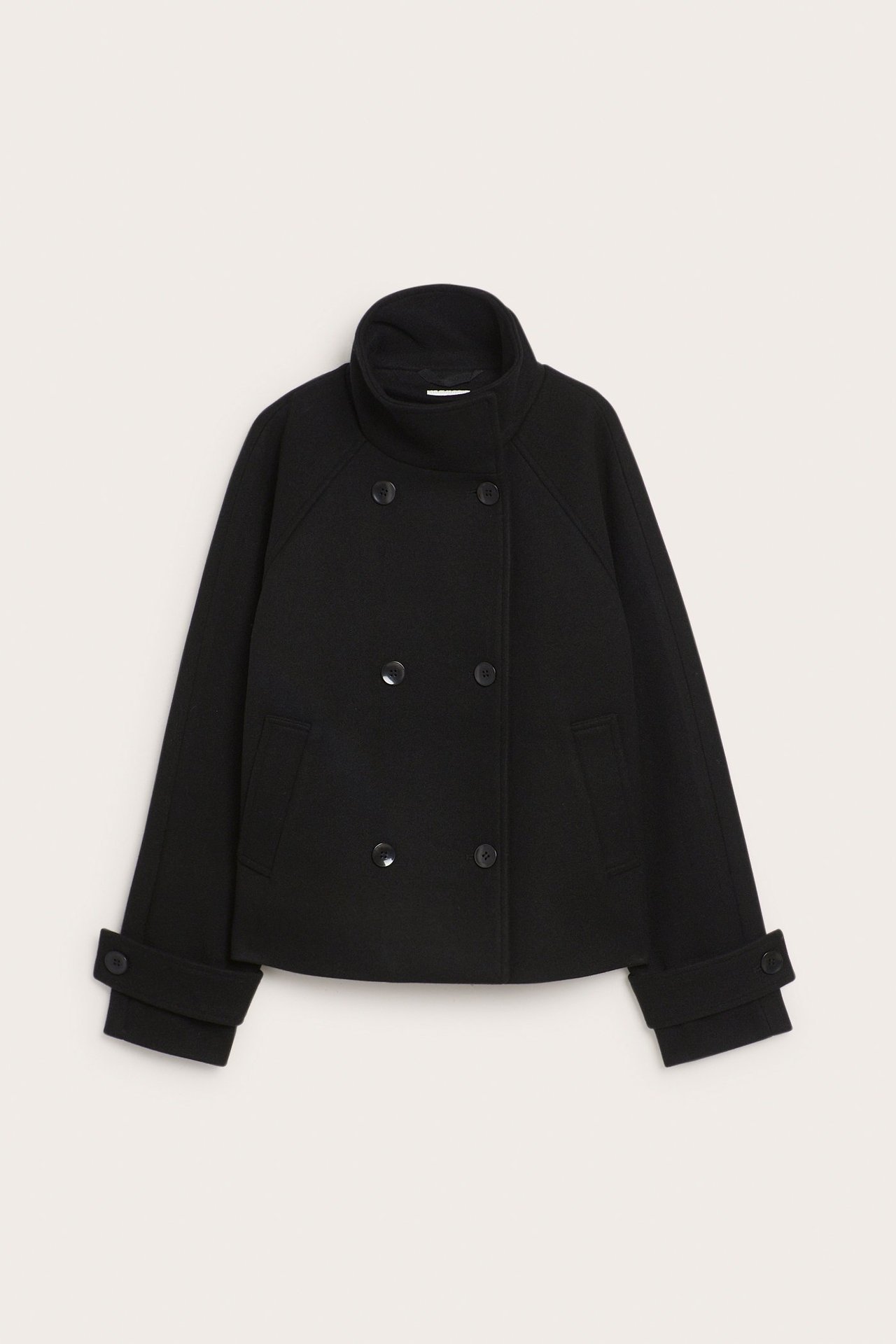 Edestä näkymä mustasta lyhyestä kaksirivisestä takista, jossa on pystykaulus ja napitetut hihansuut.