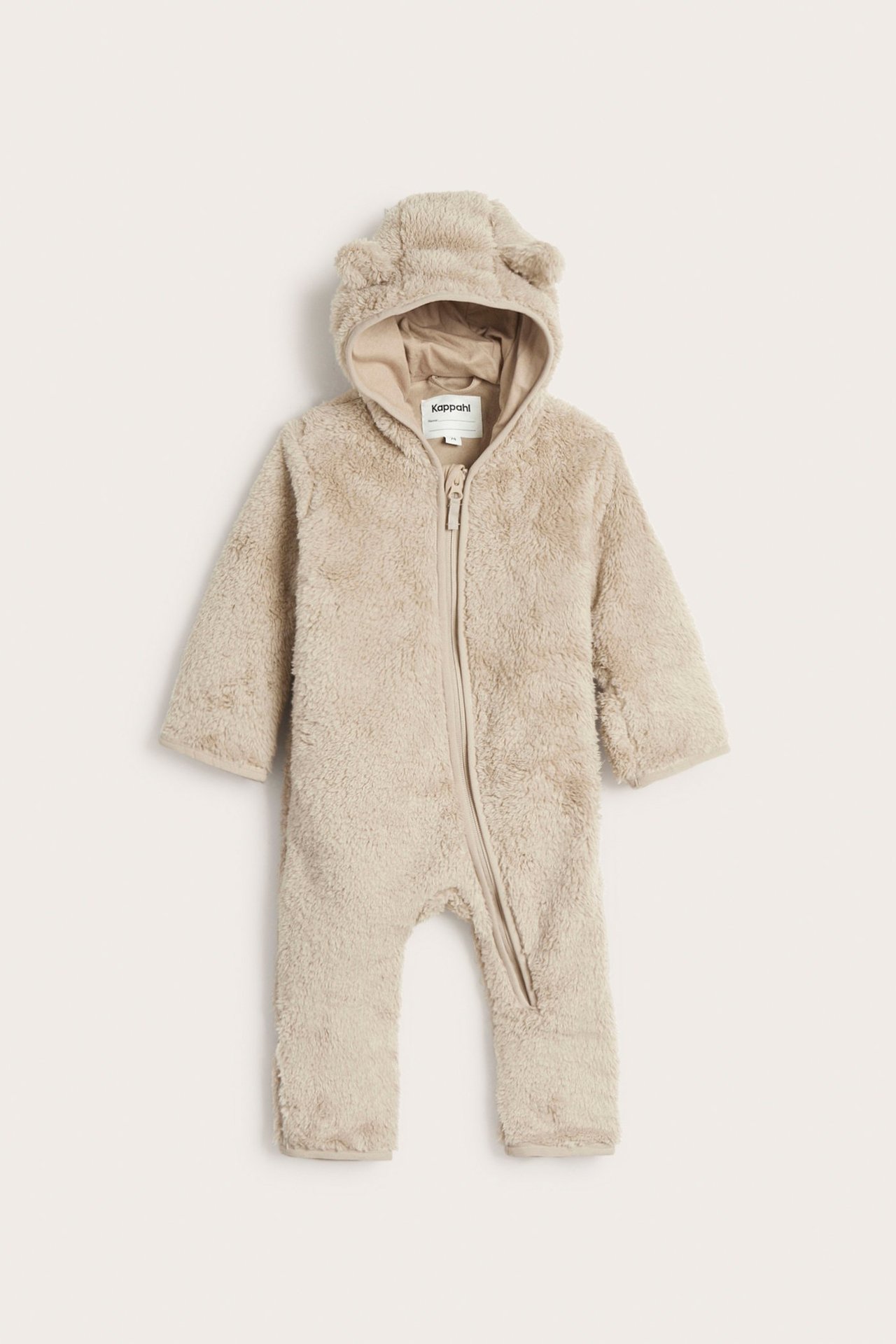 Frontvy av en beige pileoverall för baby med öron på huvan och hellång dragkedja fram.