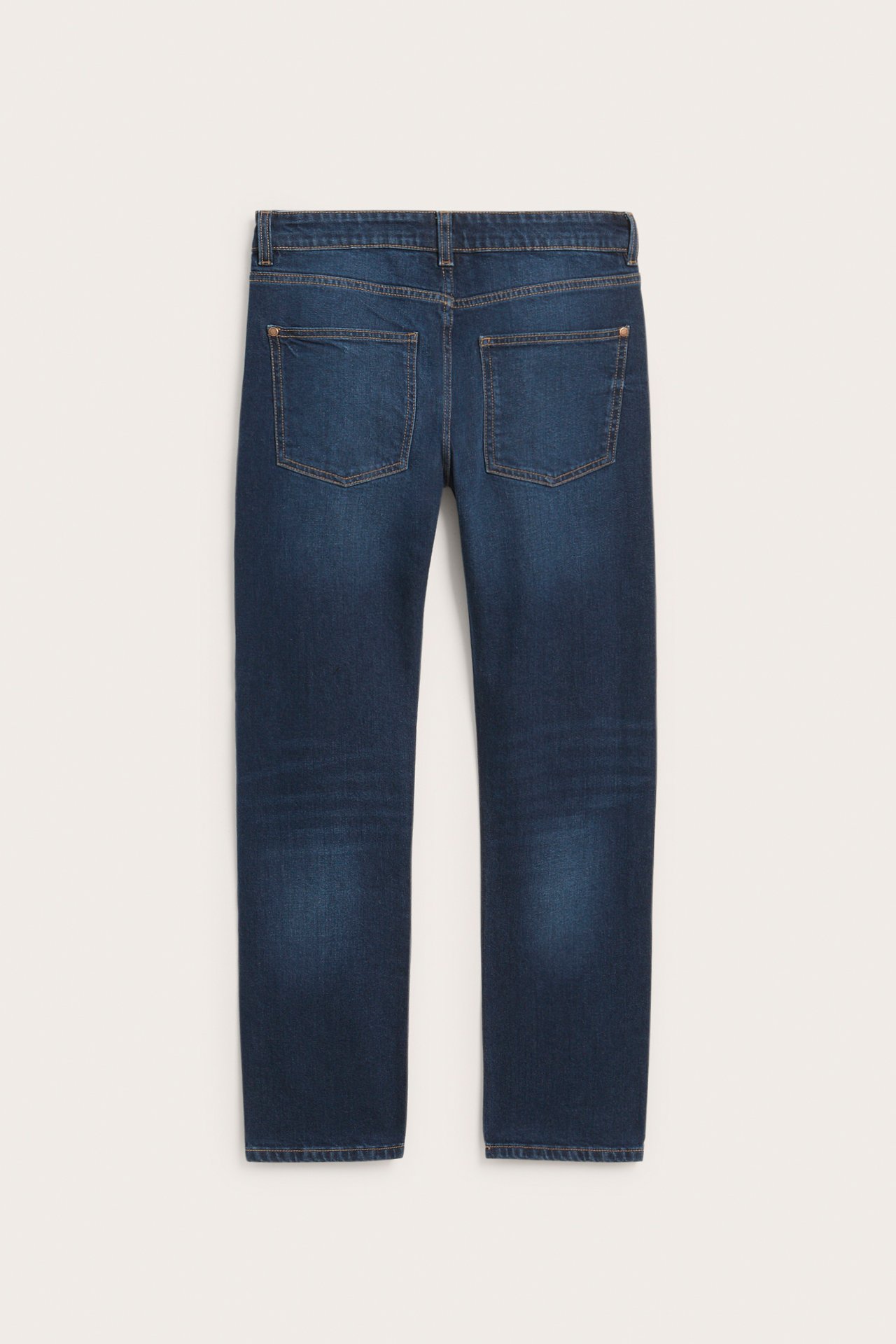 Bakfra, mørkeblå rette denimjeans med synlige baklommer.