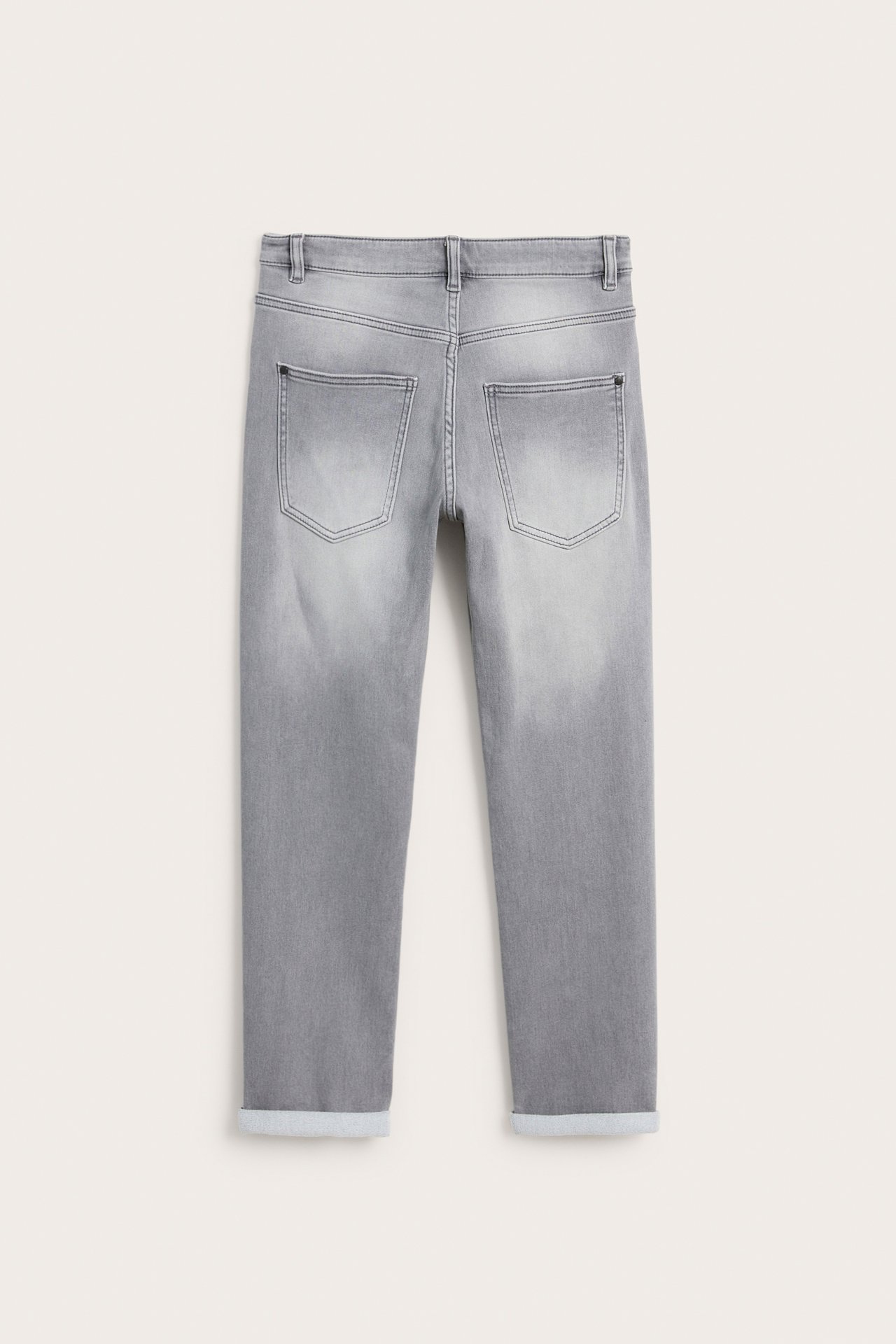 Bakifrån av barnens gråa relaxed jogger denim jeans med uppvikta benslut och två bakfickor.