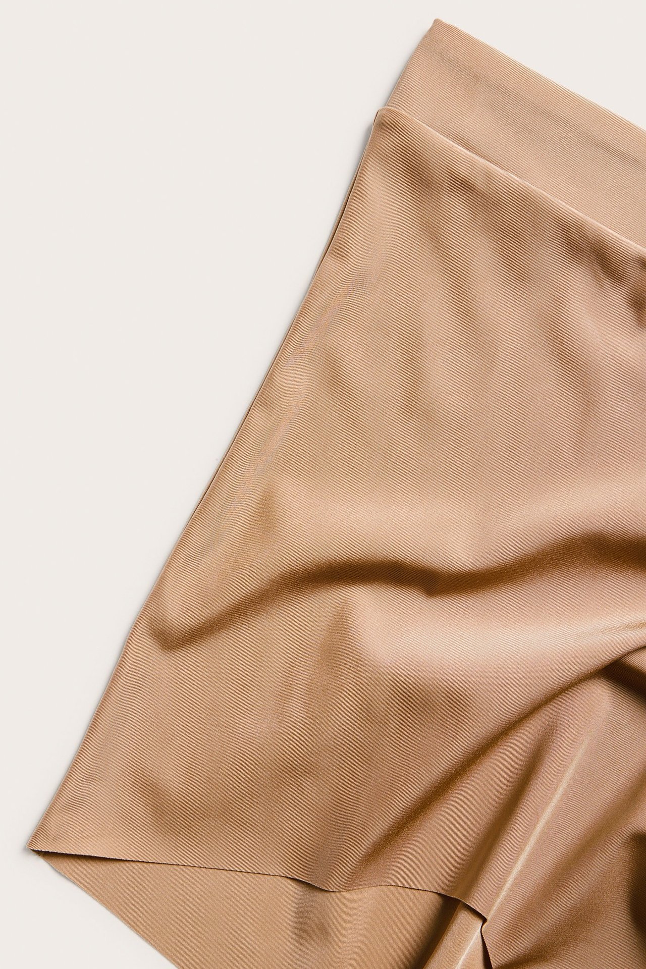 Zbliżenie brązowych, jednolitych bokserek z mikrofibry z bezszwowymi nogawkami i elastyczną talią.