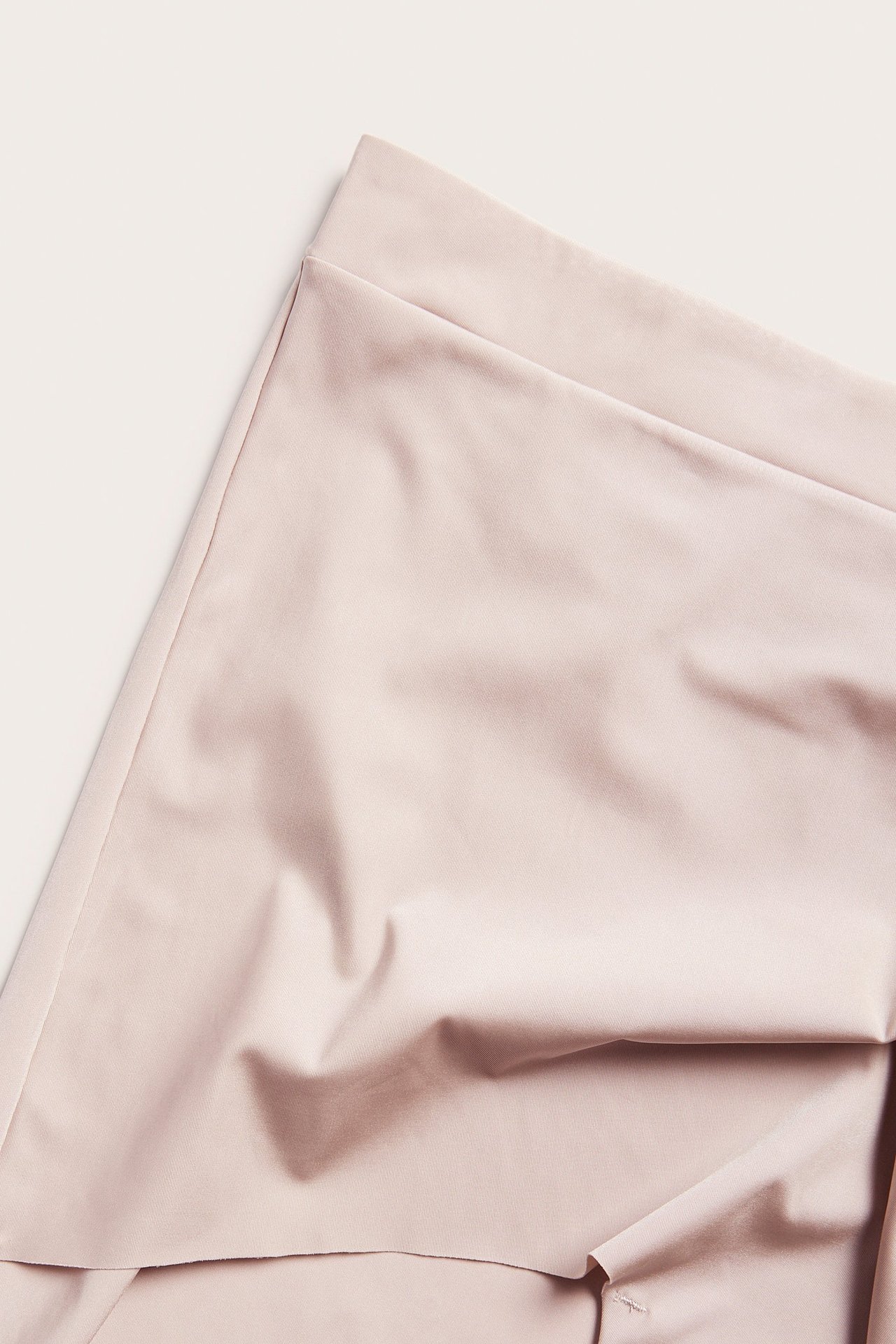 Zbliżenie na jasnoróżowe bokserki z gładkiej mikrofibry z elastyczną talią.