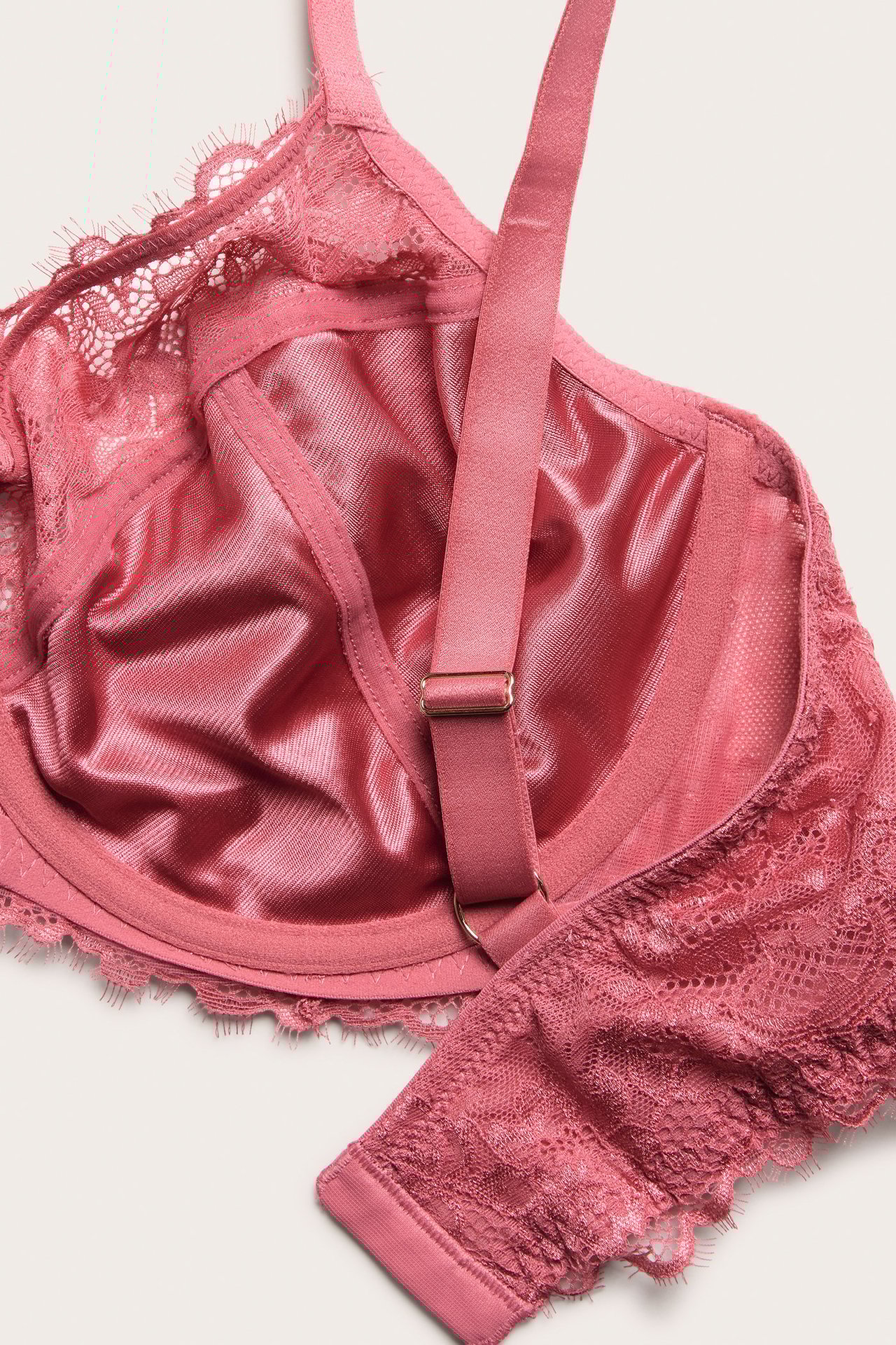 Nærbilde av en korallfarget uvattert blonde-BH med bøyle, justerbare stropper og glatt innerfôr.