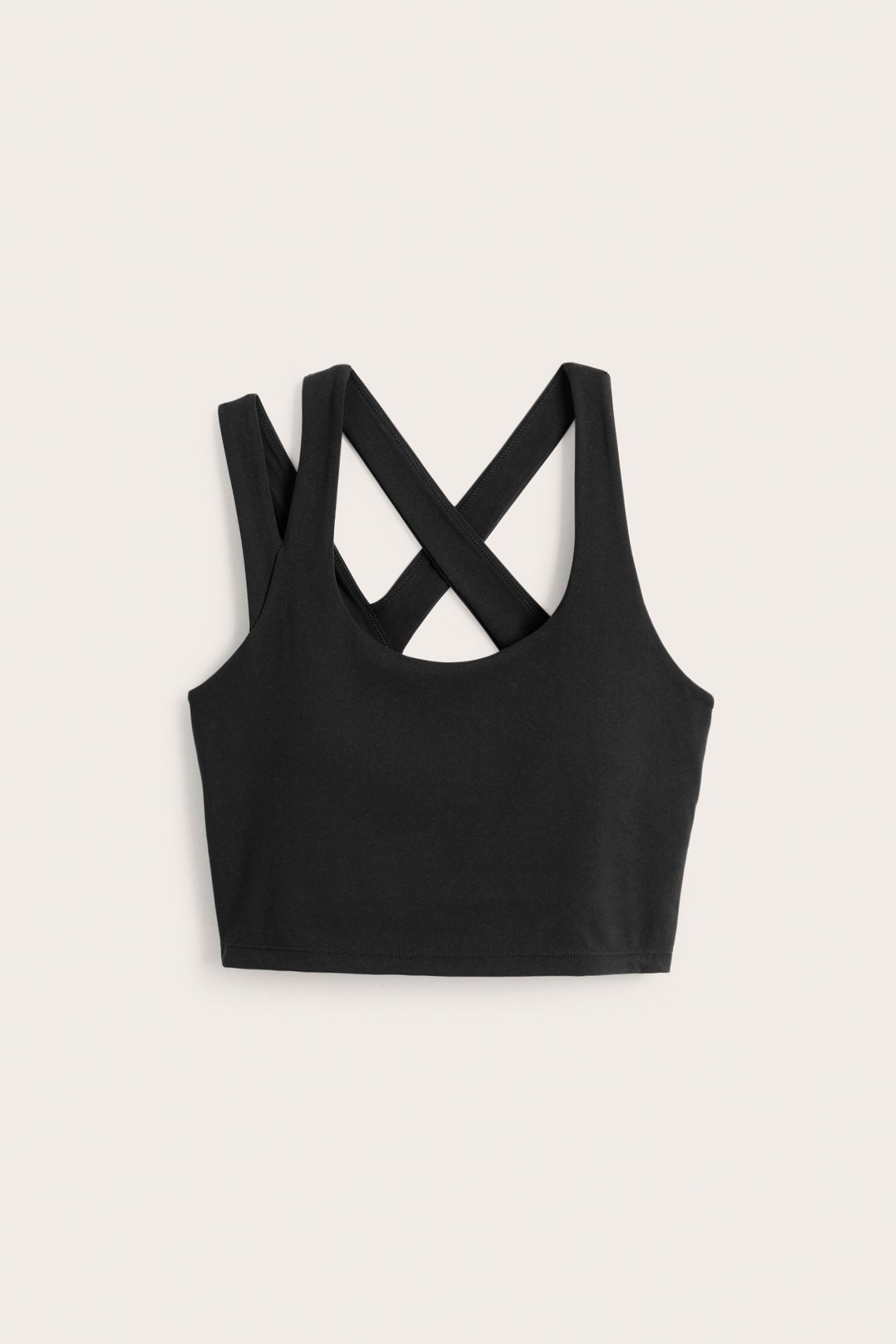 Forfra, svart ensfarget sportstopp med kryssede skulderstropper bak.