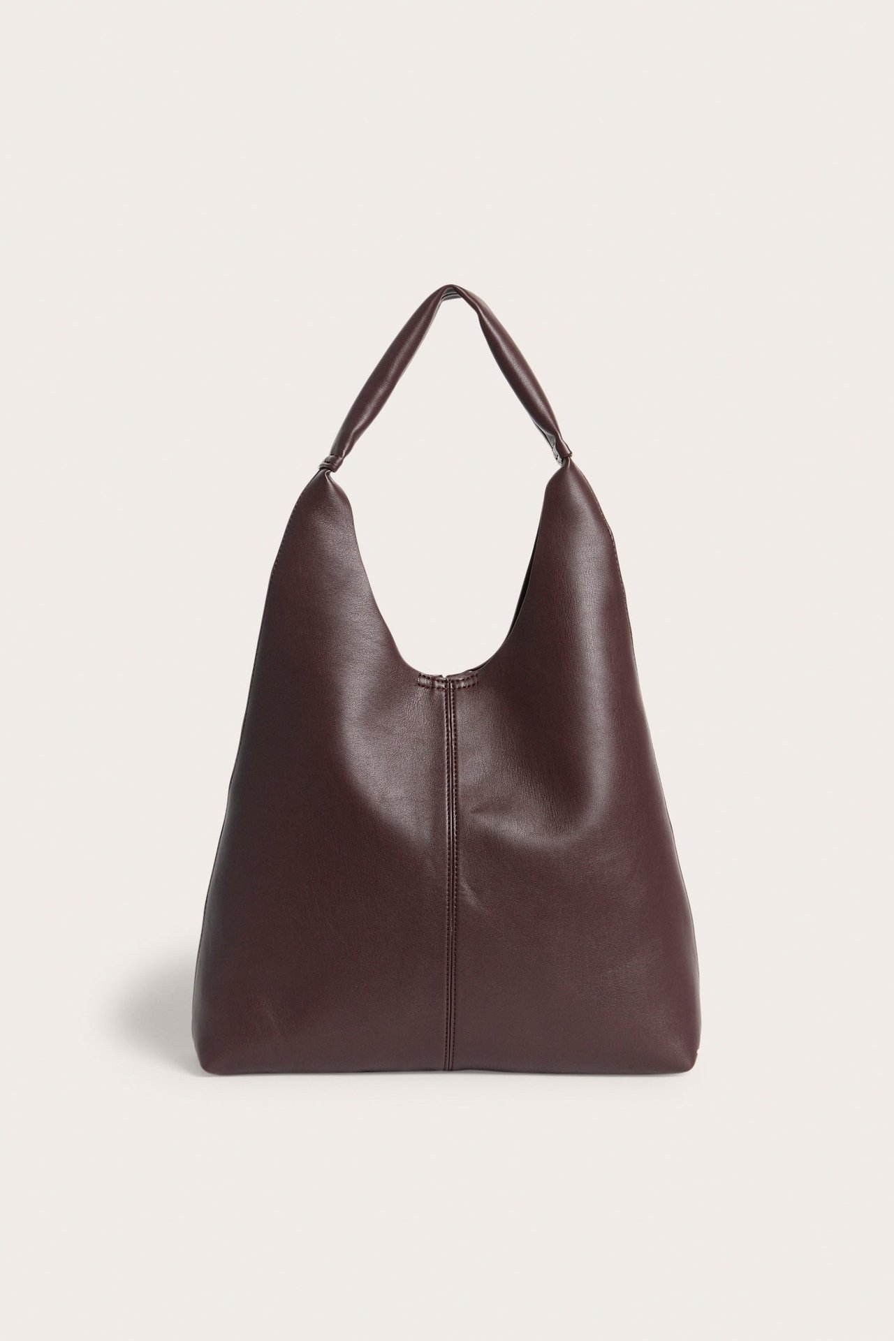 Framifrån: Enfärgad vinröd hobo-väska i skinnimitation med ett handtag.