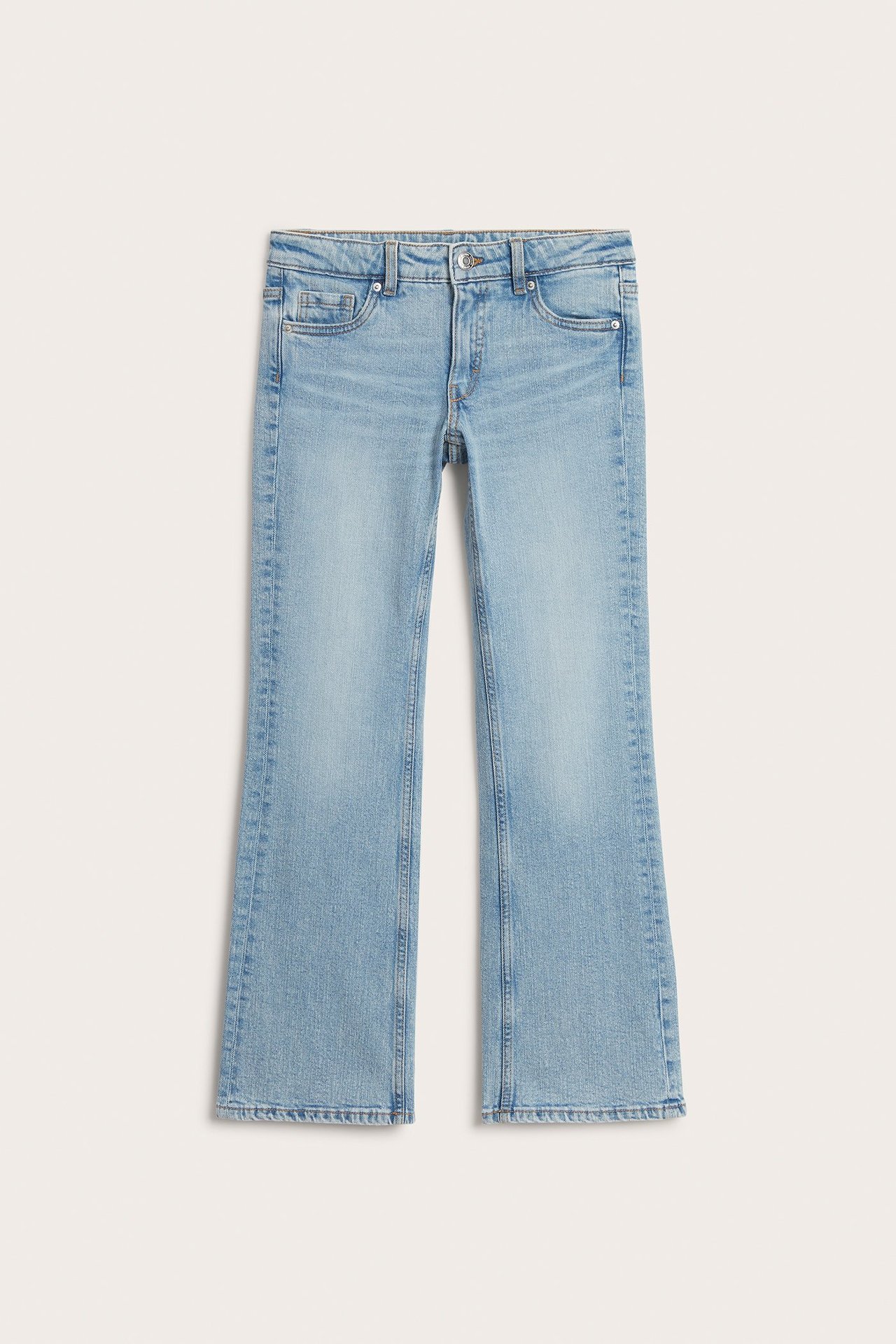 Frontvy av ljusblå bootcut jeans med låg midja, knapp och dragkedja.