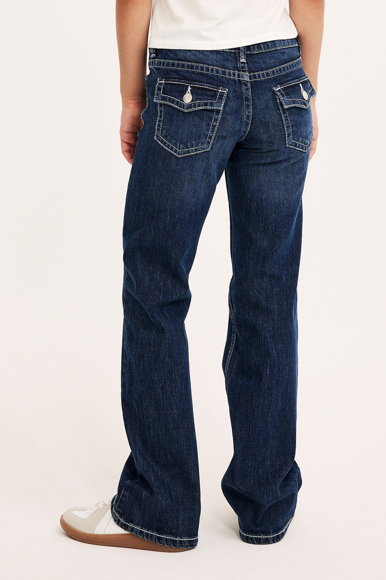 Dzieci jeansy typu bootcut w ciemnym denimu, niska talia, regulowane, tylne kieszenie.
