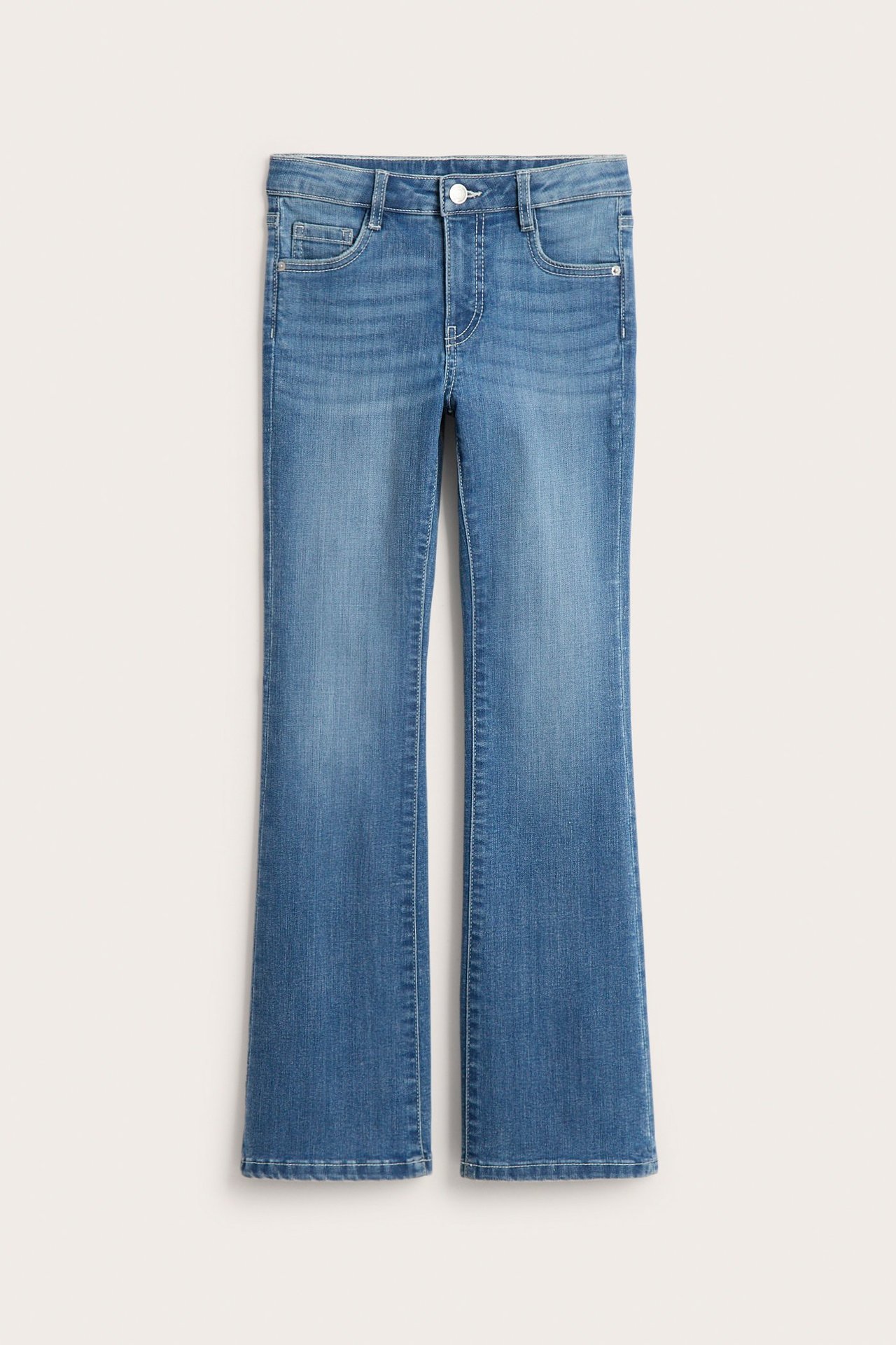 Widok z przodu dziecięcych, obcisłych niebieskich dżinsów bootcut z niskim stanem, guzikiem i zamkiem.