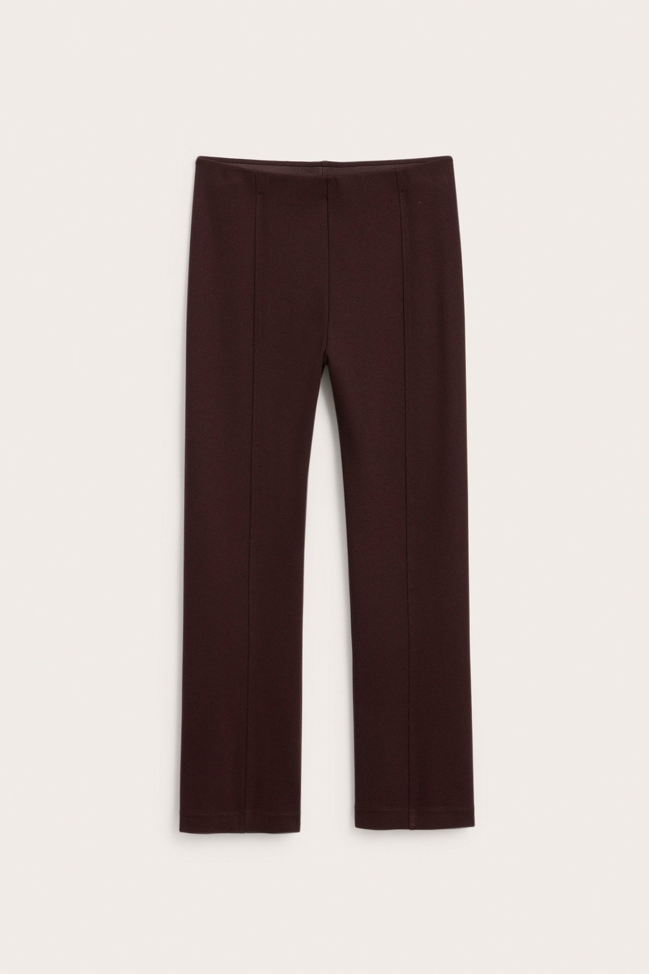 Widok z przodu ciemnoczerwonych spodni dresowych z rozszerzanymi nogawkami i szwami z przodu.