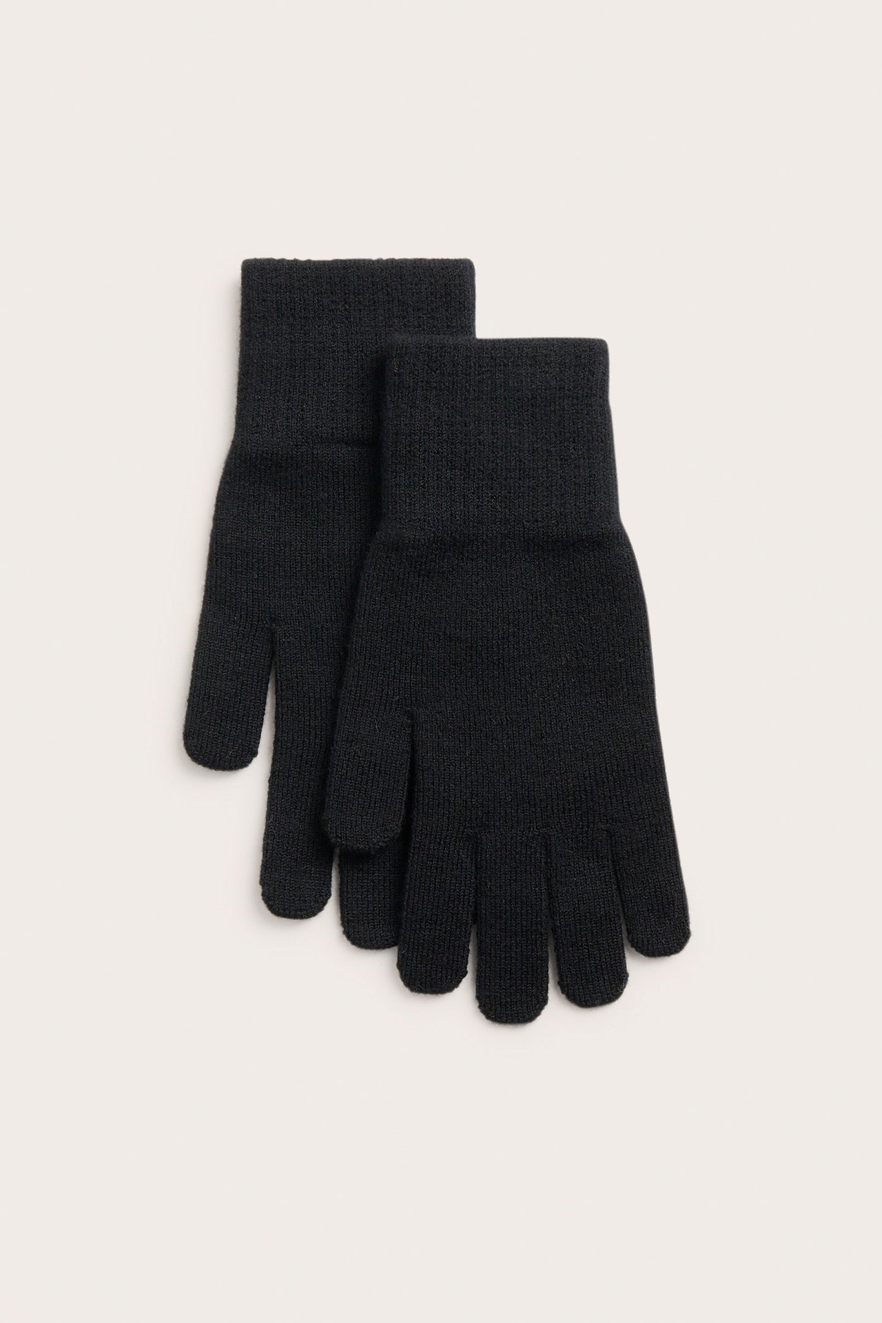 Widok z góry na parę czarnych dzianinowych rękawiczek ze ściągaczami.