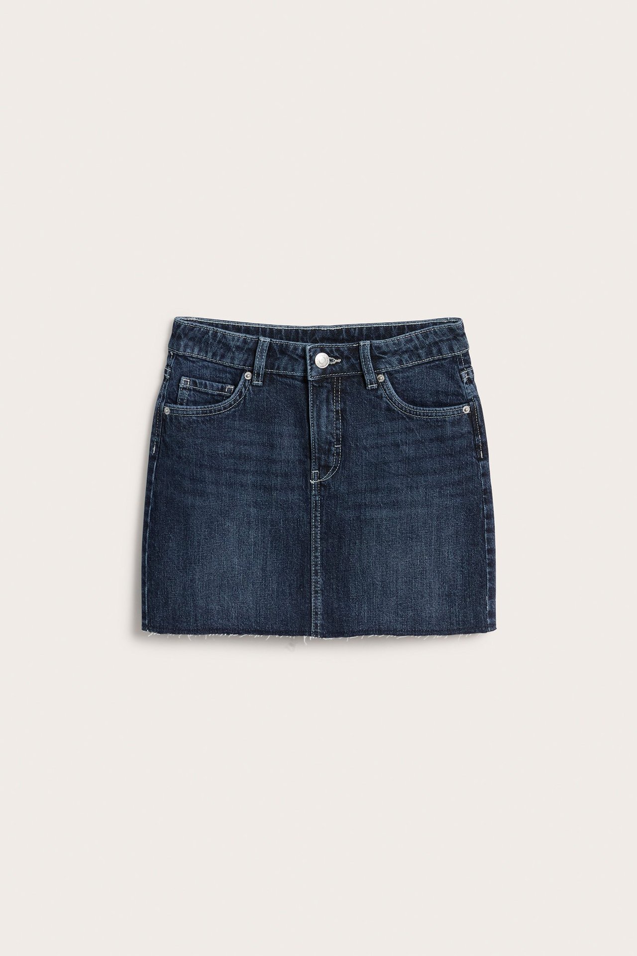 Framifrån: mörkblå kort jeanskjol med framfickor, knapp-dragkedja och fransig nederkant.