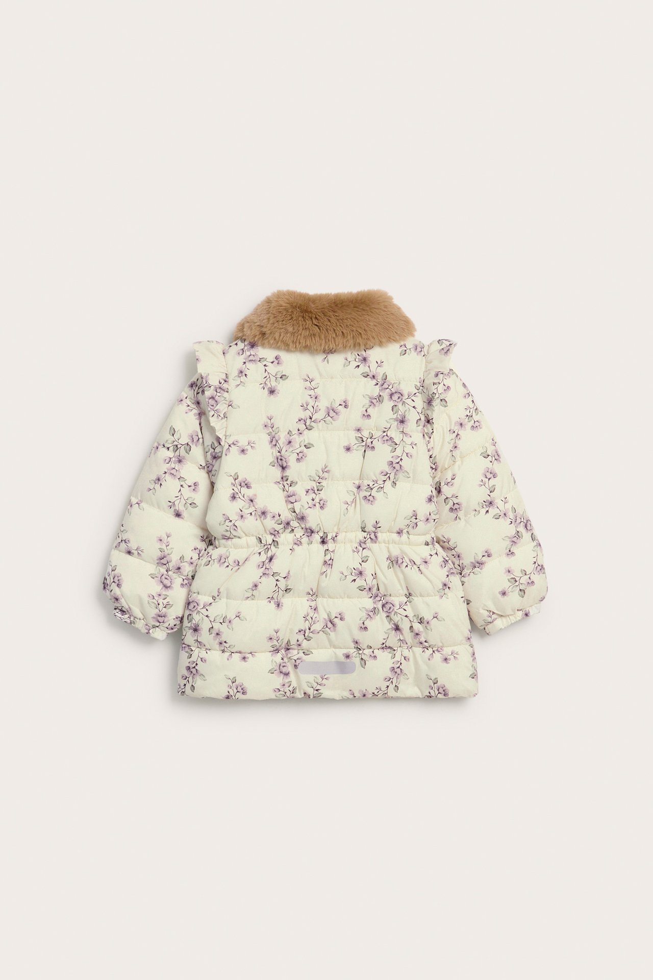 Bakifrån: en vadderad barnjacka i ljusbeige med blommigt mönster, brun fuskpäls krage och volanger.
