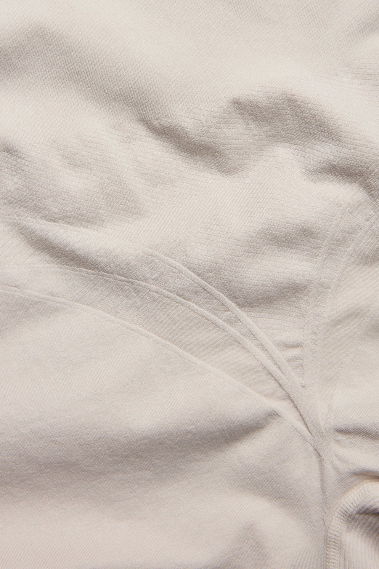 Zbliżenie na jasnobeżowe, bezszwowe szorty modelujące z subtelnymi detalami.