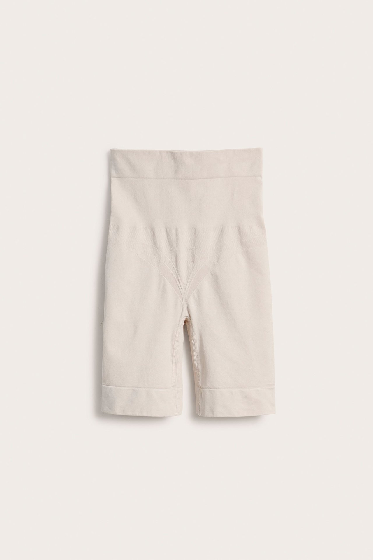 Frontvisning av lysebeige sømløse high-waist shapingshorts i polyamid og elastan.