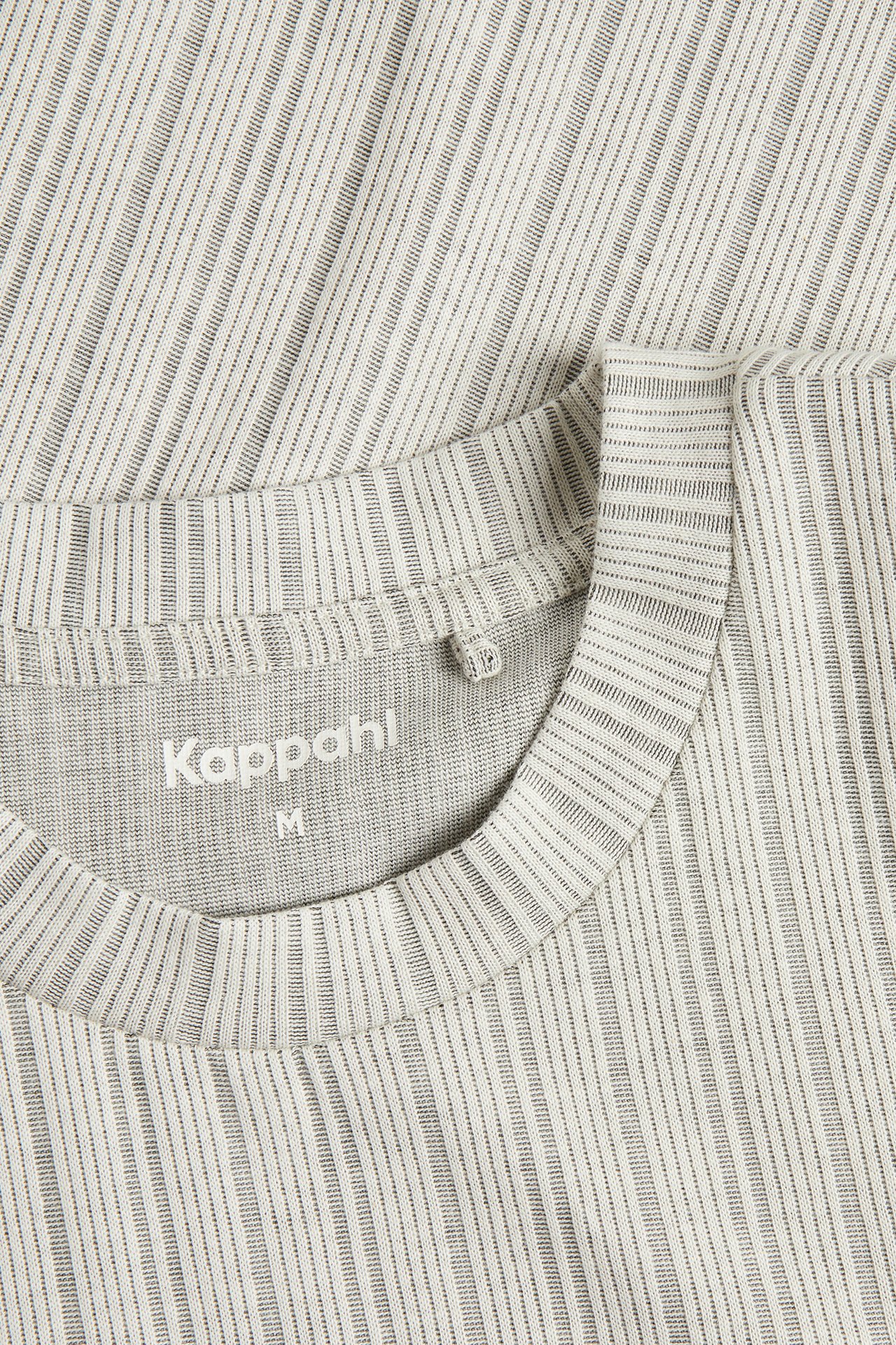 Närbild av en offwhite herr T-shirt med rund hals och strukturerat mönster.