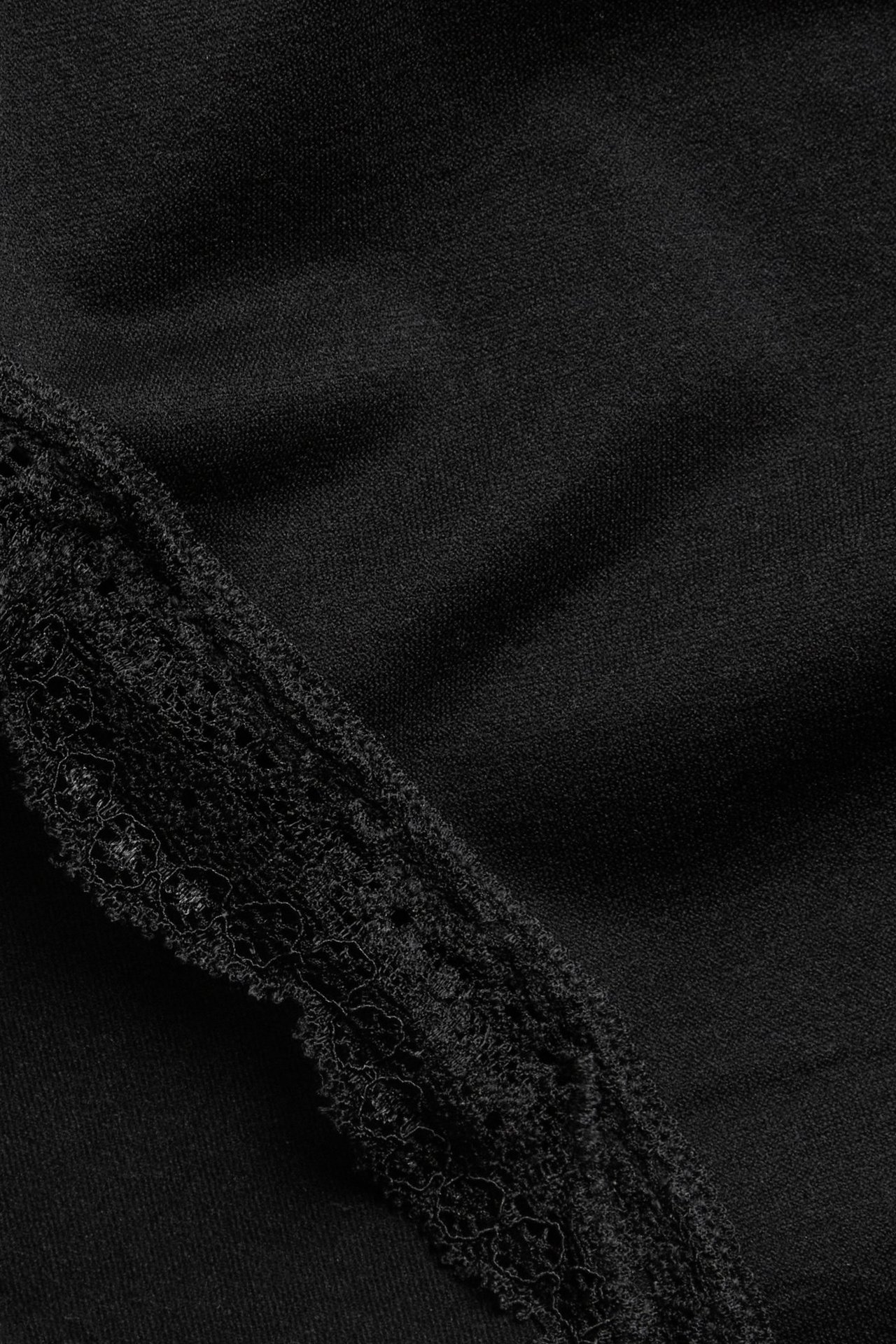 Zbliżenie czarnych, bezszwowych majtek z delikatną koronkową krawędzią.