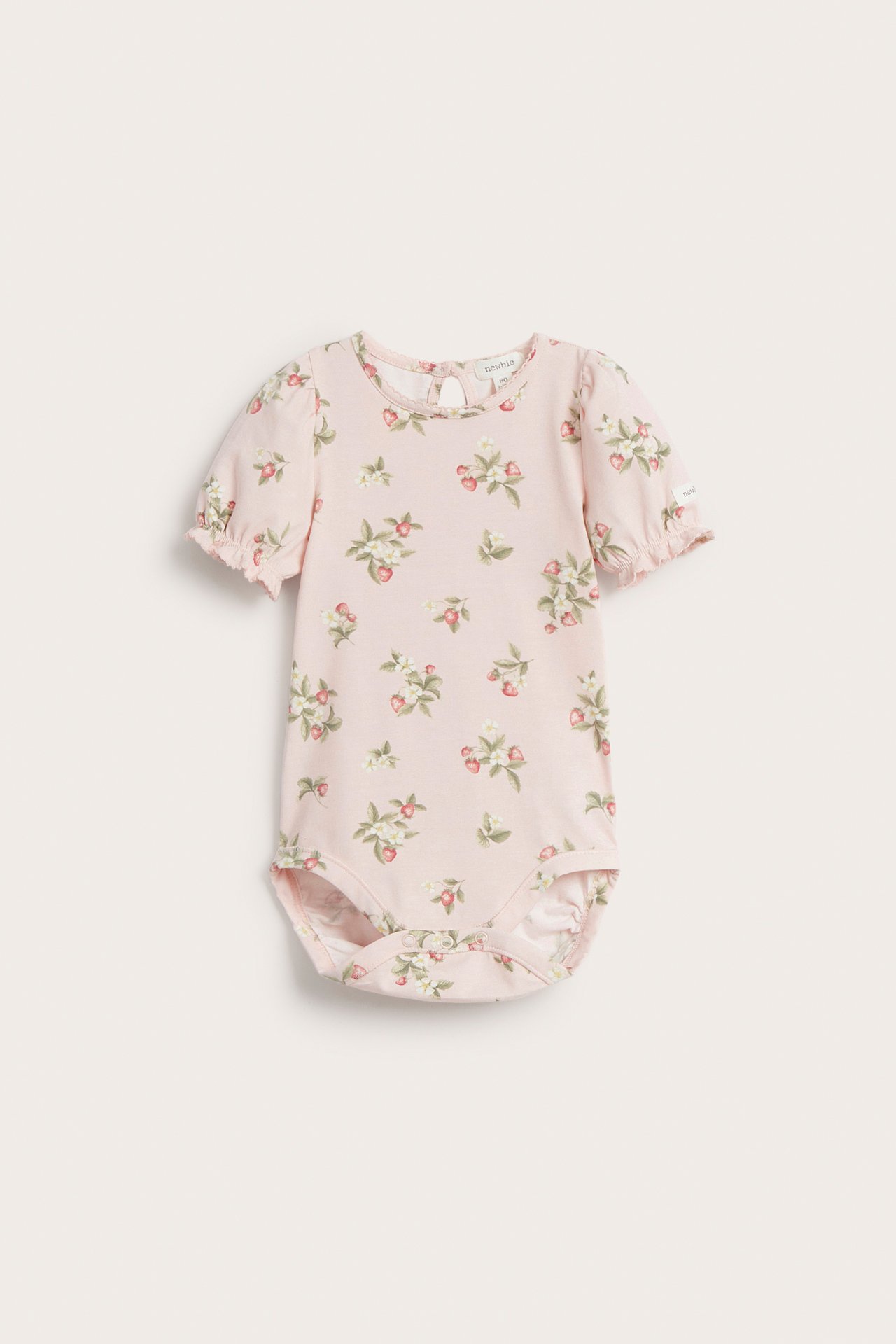Frontvisning av en lyserosa kortermet babybody med jordbærblomstermønster og puffermer.