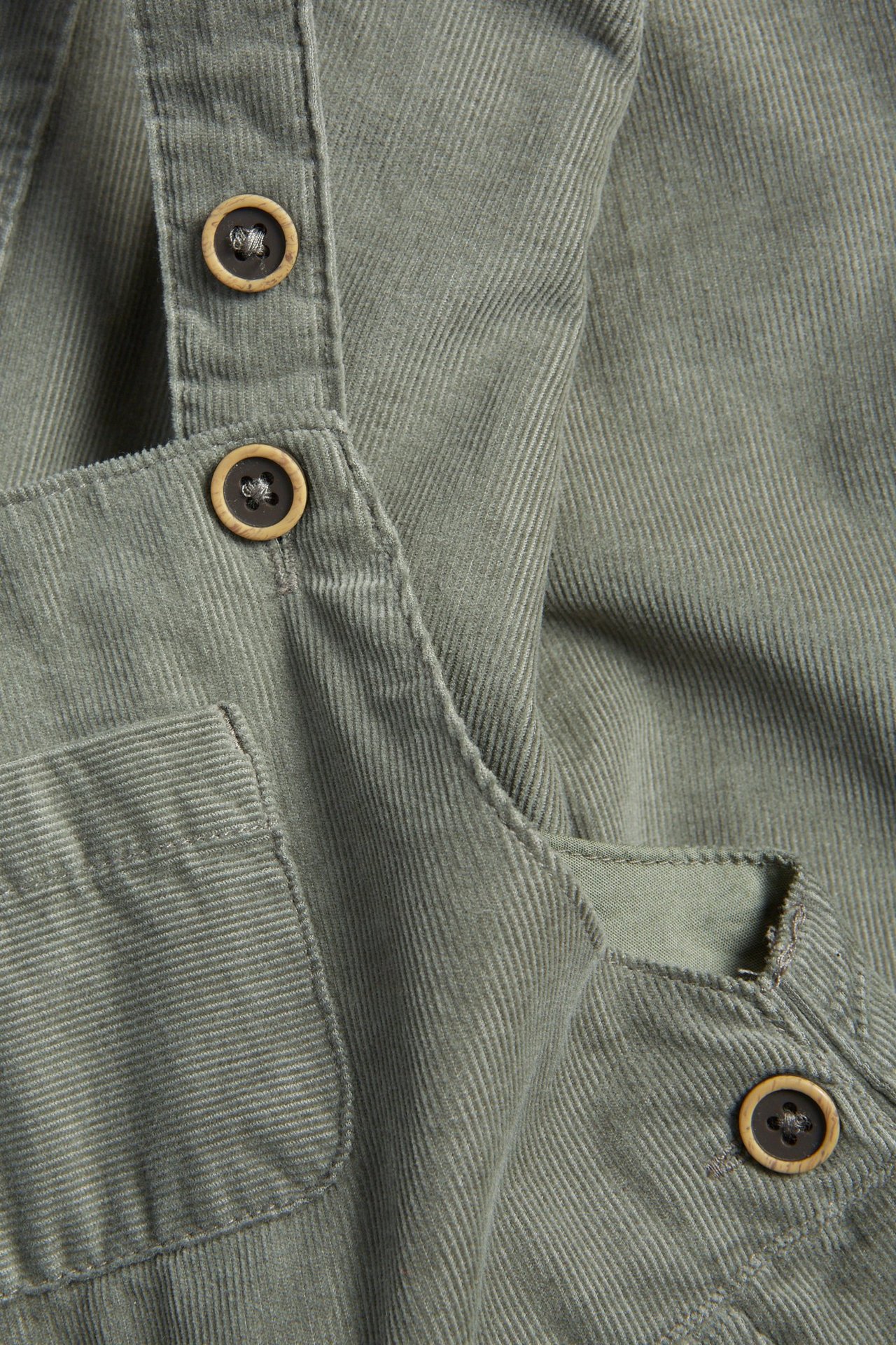 Ciemnozielone manchestrowe ogrodniczki dla dziecka, regulowane szelki, guziki, ściągacze u nogawek.