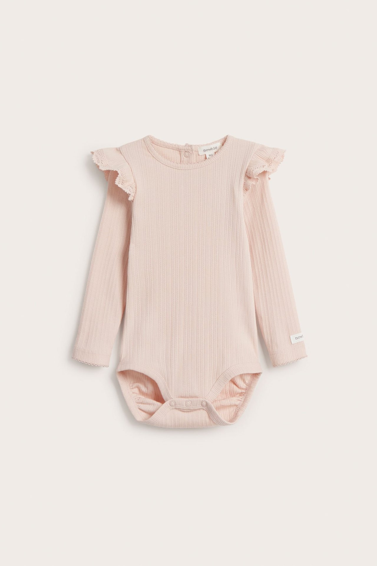 Frontvy av en ljusrosa ribbad babybody med långa ärmar, volanger på axlarna och tryckknappar.