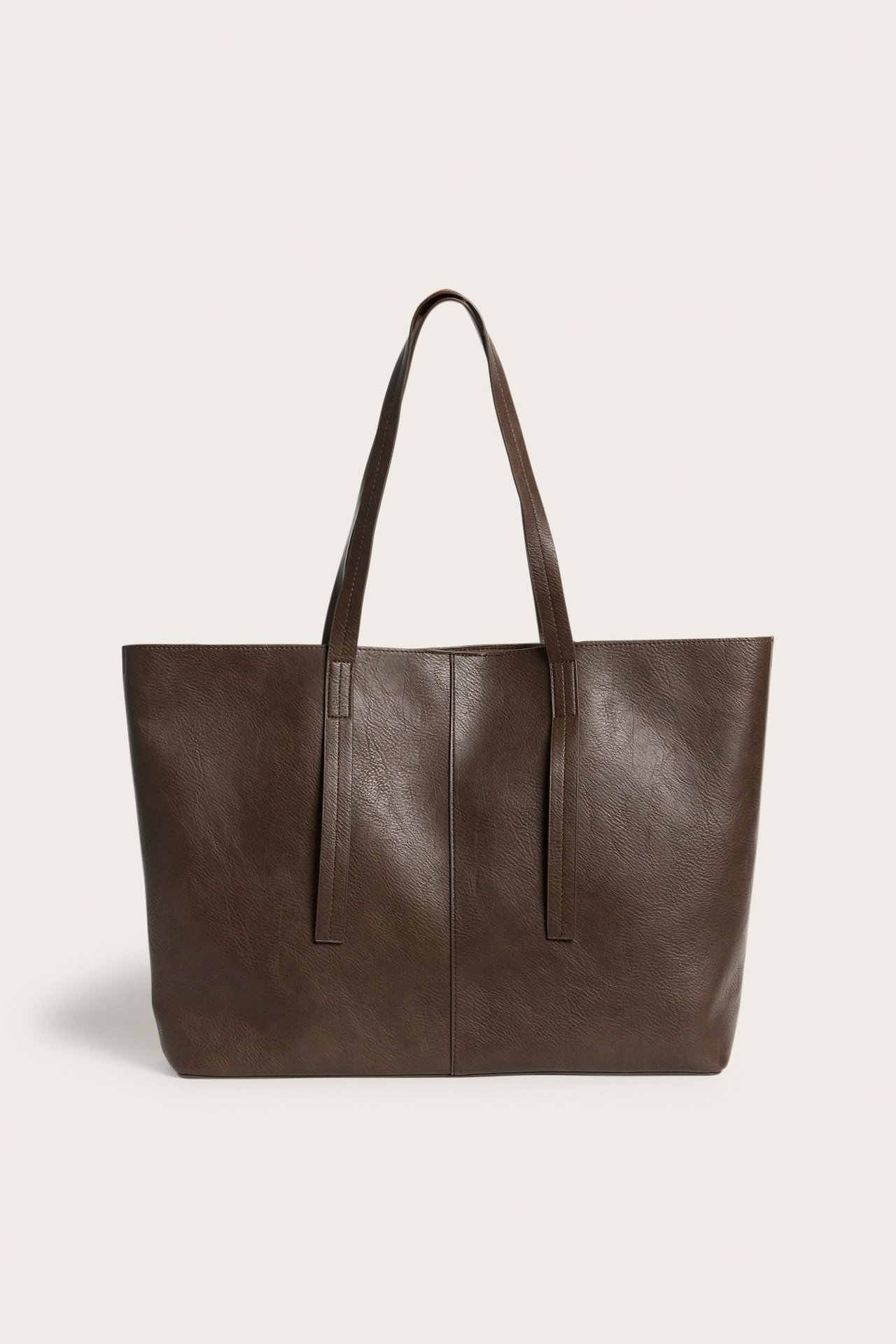 Frontvisning av en mørkebrun totebag i skinnimitasjon med to skulderstropper.