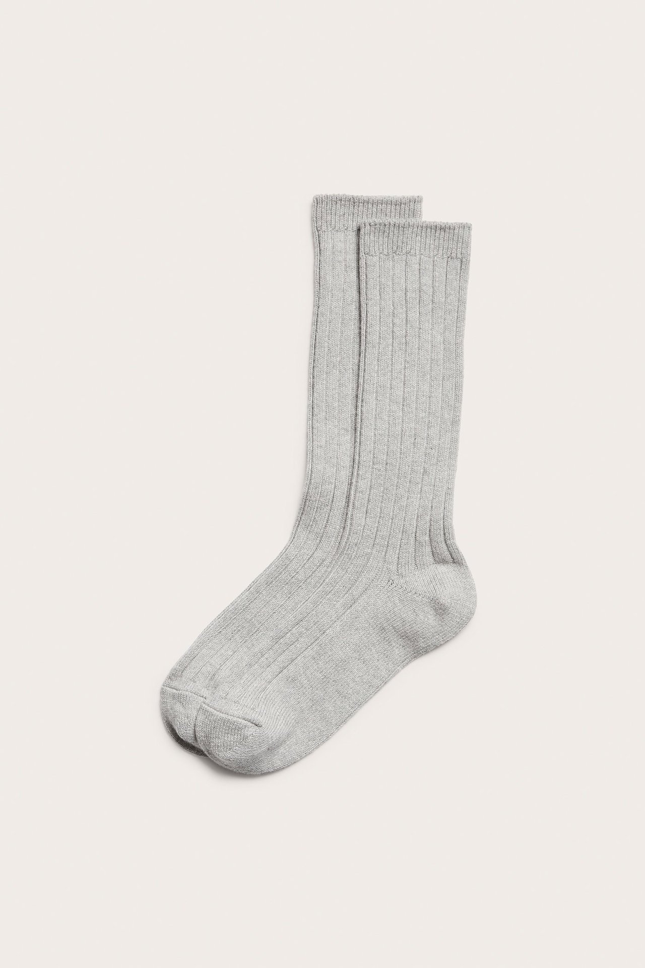 Widok z przodu pojedynczej jasnoszarej prążkowanej bawełnianej skarpetki, jednokolorowej.