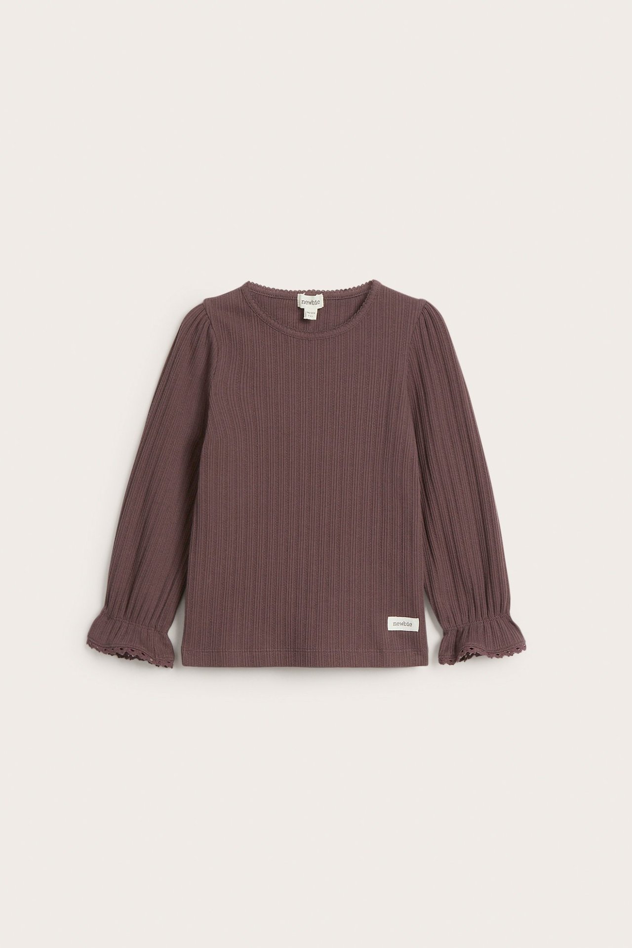 Edestä näkymä lasten yksivärisestä lila ribbineuleisesta pitkähihaisesta paidasta, jossa on pitsireunaiset röyhelöhihansuut.