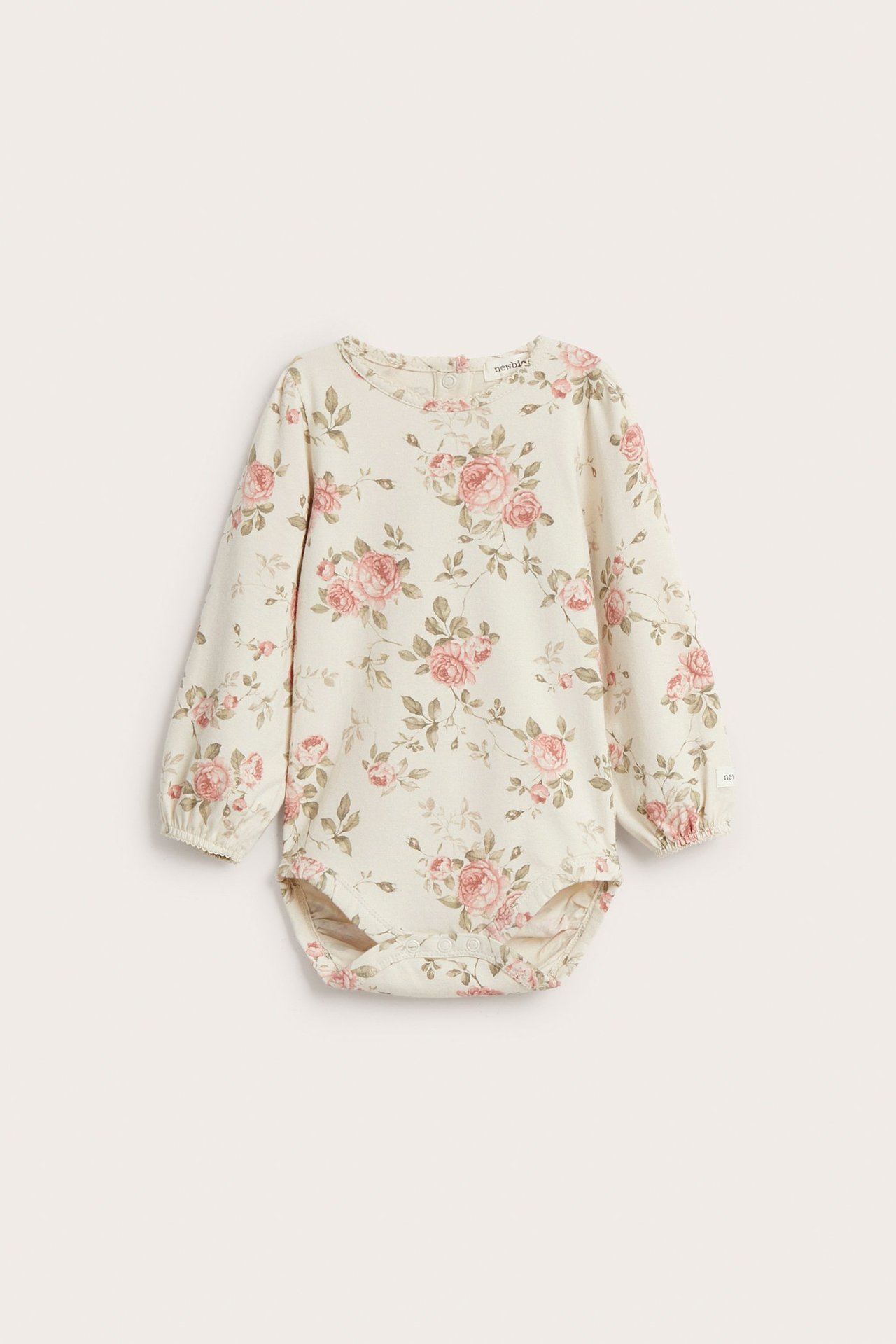 Widok z przodu: Jasnobeżowe body niemowlęce w różowy kwiatowy wzór, z długimi bufiastymi rękawami.