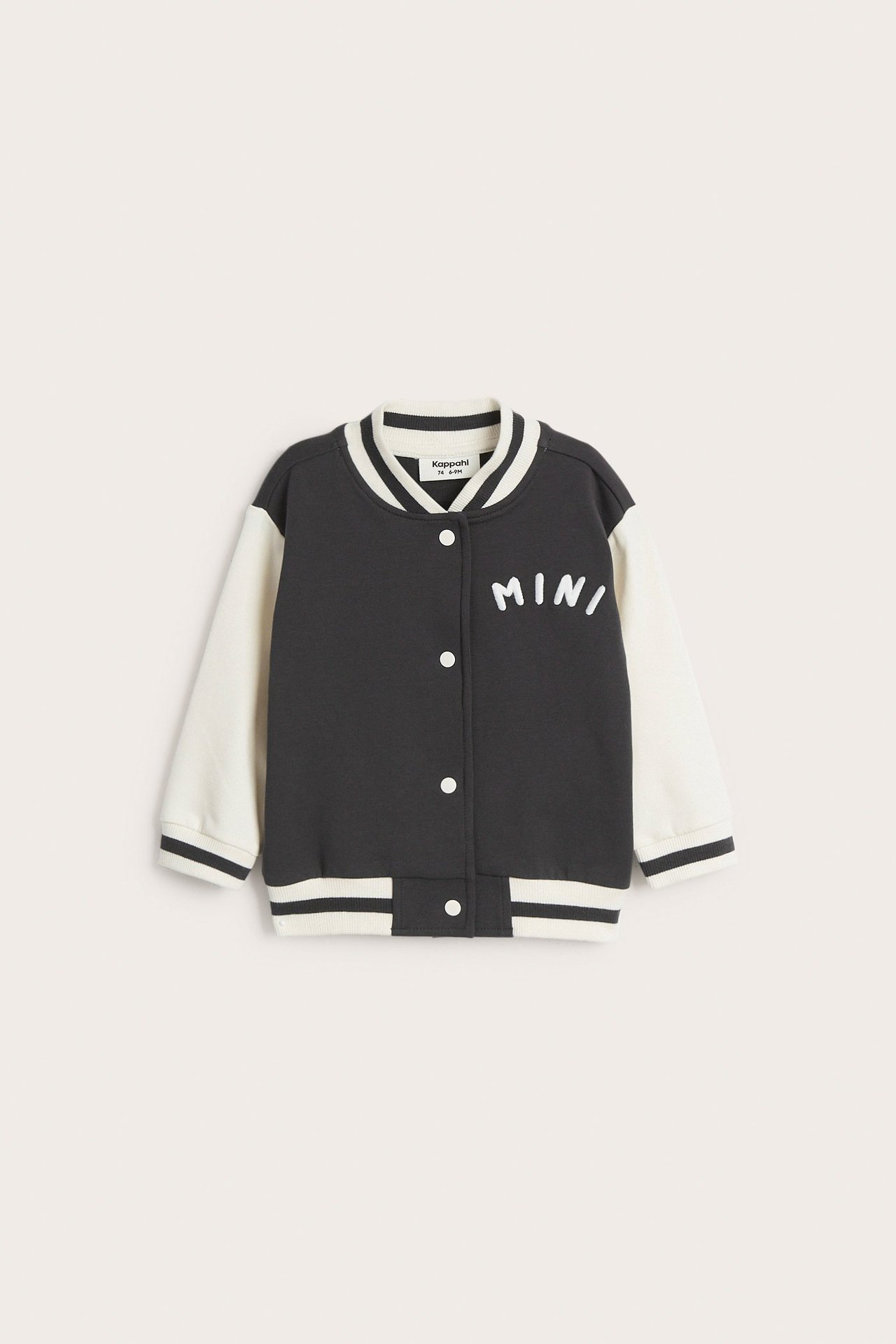 Framsida av en baby mörkgrå och benvit baseballjacka med vita knappar och 'MINI' brodyr.