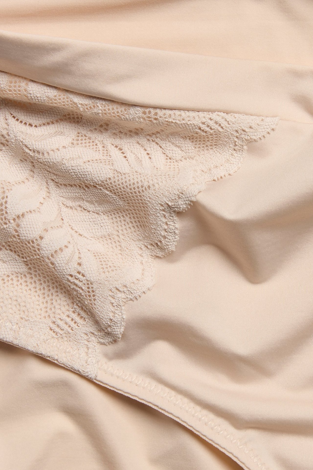 Zbliżenie na jasnoróżowe majtki typu brief z mikrofibry z koronkowymi aplikacjami i elastycznym pasem.