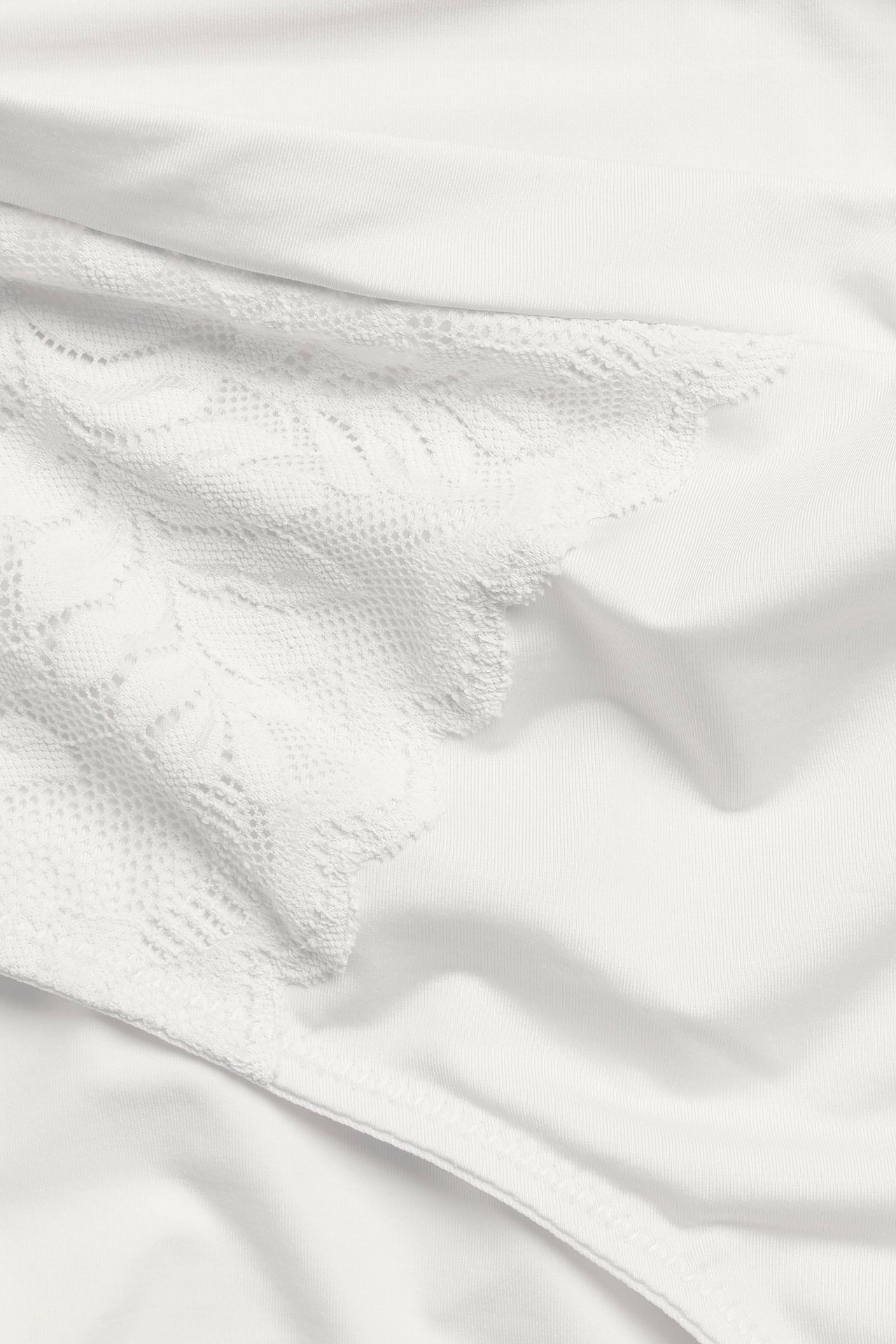 Zbliżenie na majtki typu brief w kolorze ecru, z mikrofibry, z koronkowymi aplikacjami i elastycznym pasem.