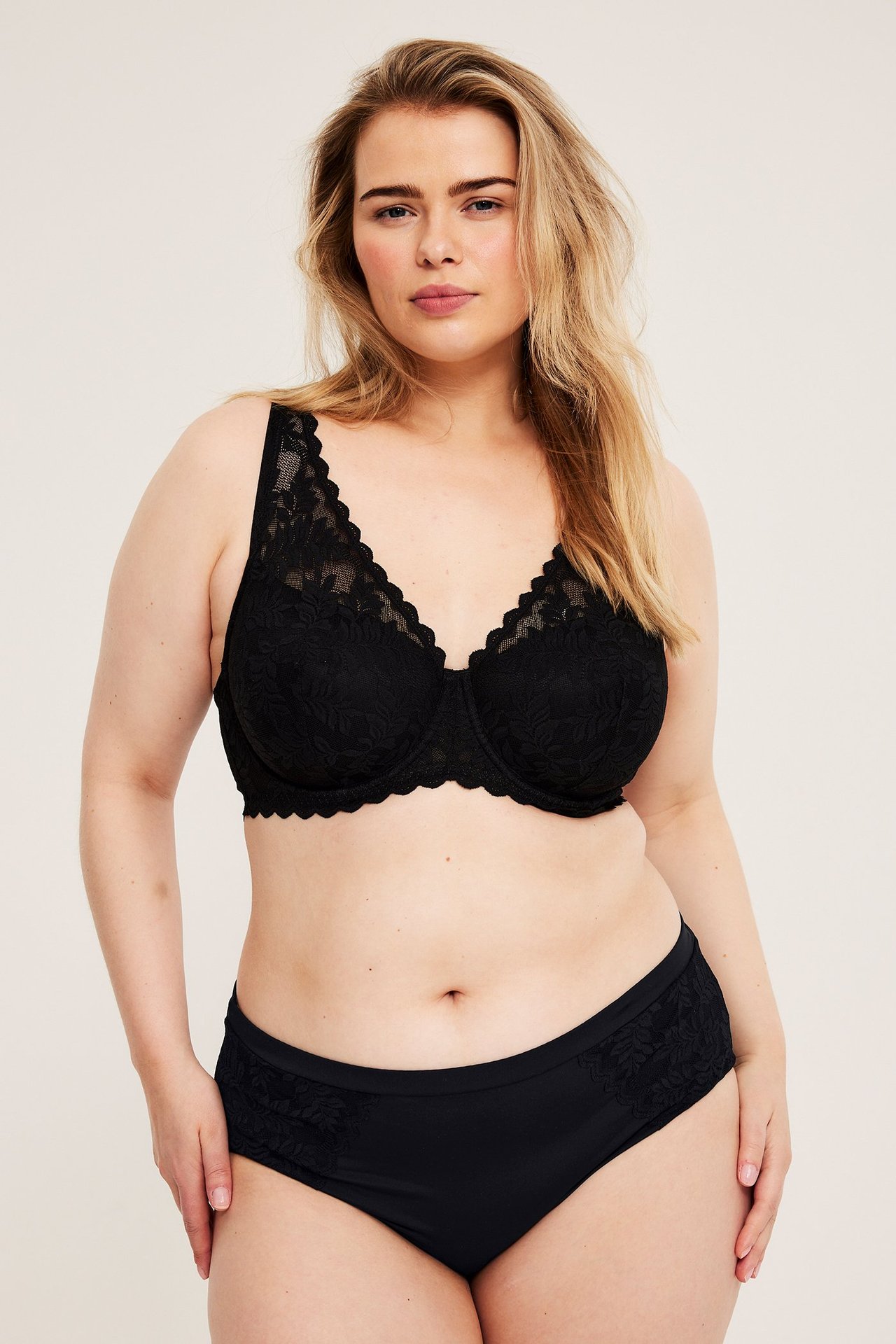 Widok z przodu: kobieta w czarnych figach micro z koronką i pasującym czarnym biustonoszu.
