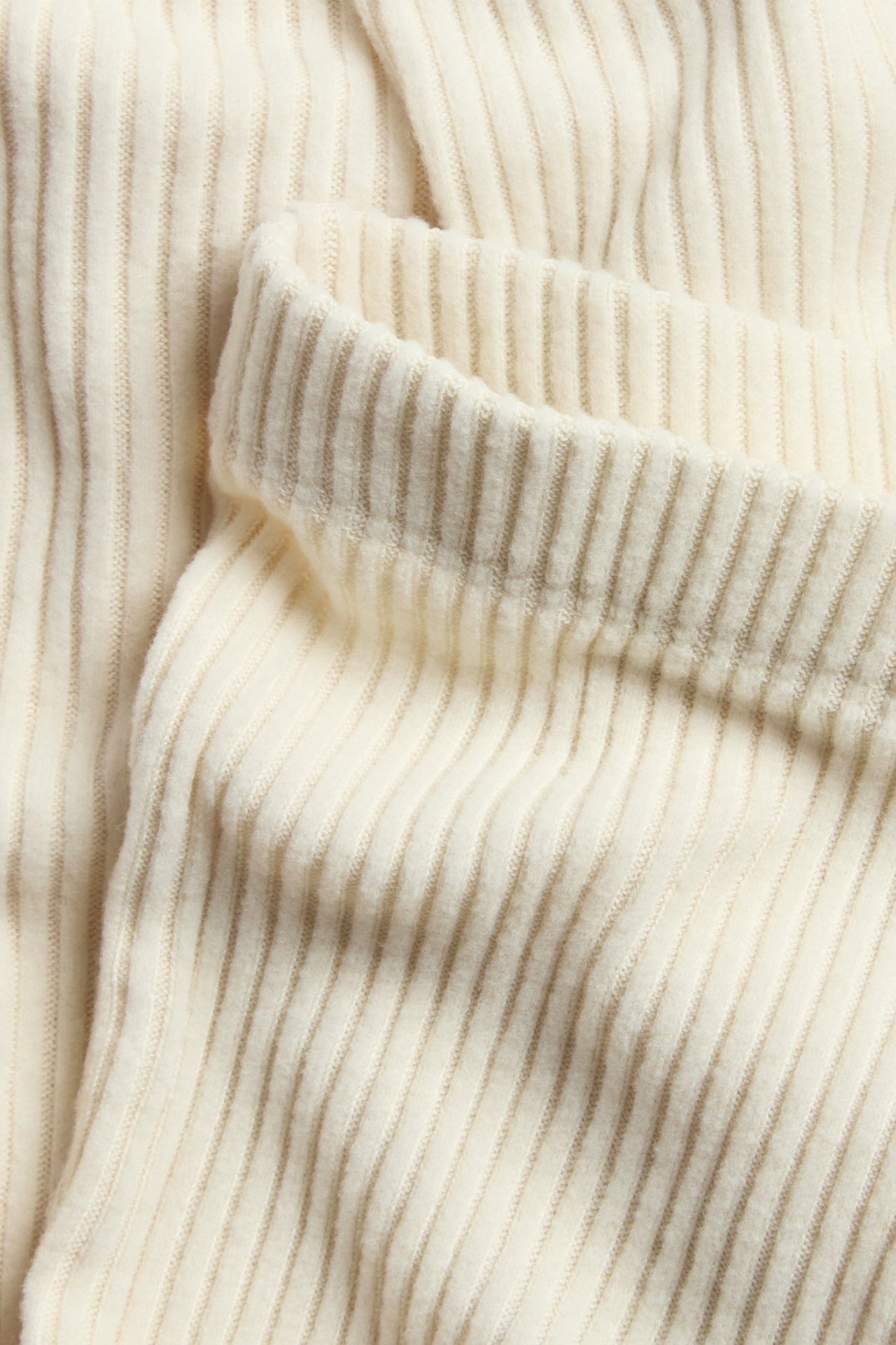 Jasnobeżowe legginsy w miękkim prążkowanym materiale, dopasowane, jednolite.