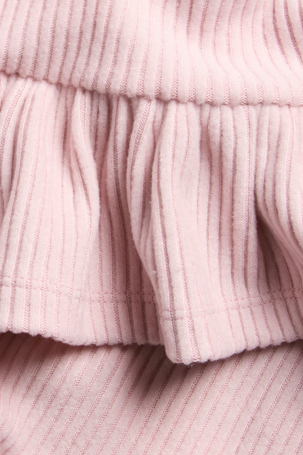 Vaaleanpunainen pitkähiha peplum-ylipaita pehmeästä ribkankaasta lapsille.