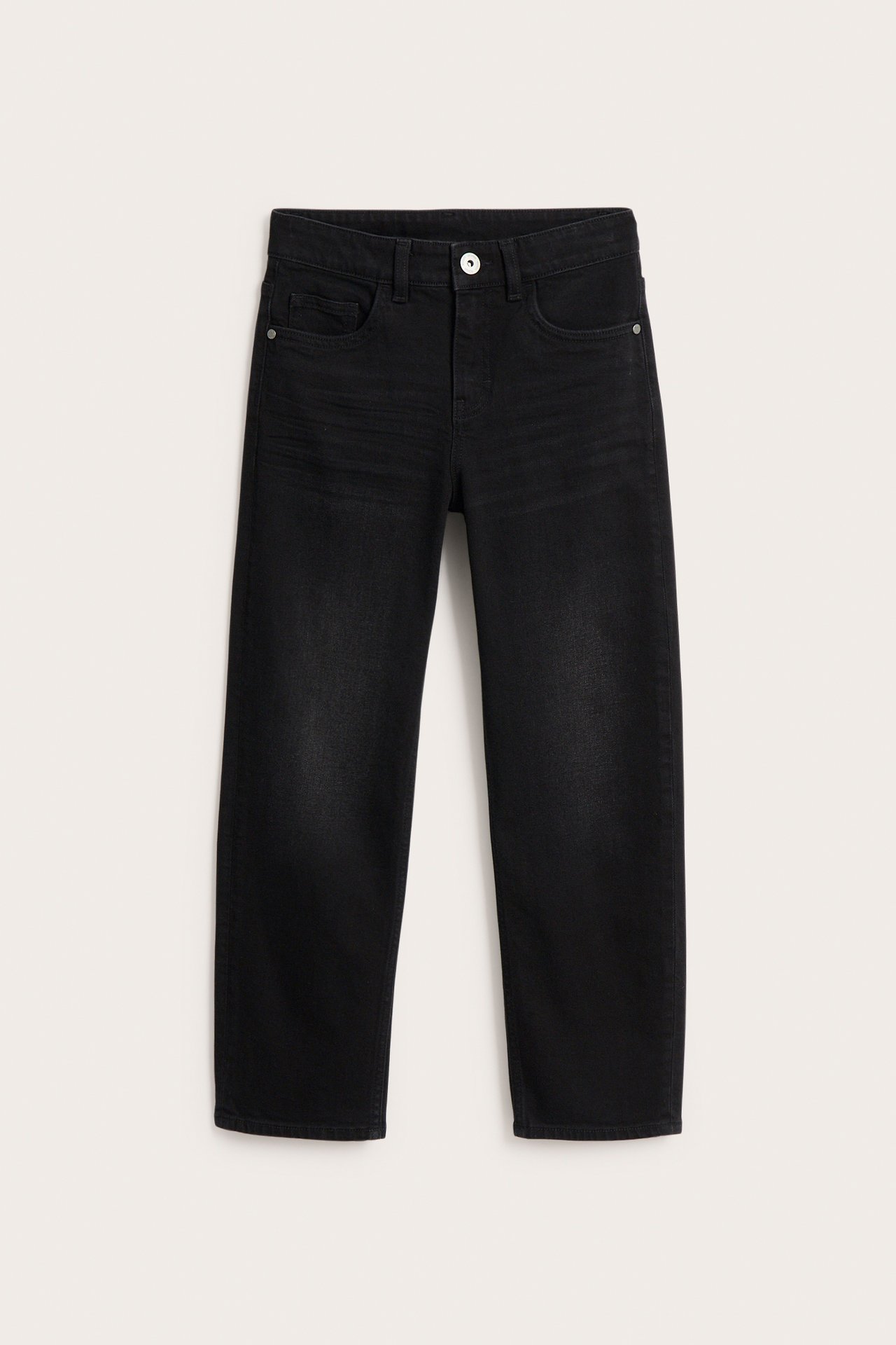 Mustat löysät farkut, joissa on keskikorkea vyötärö ja viisi taskua, edestä nähtynä.