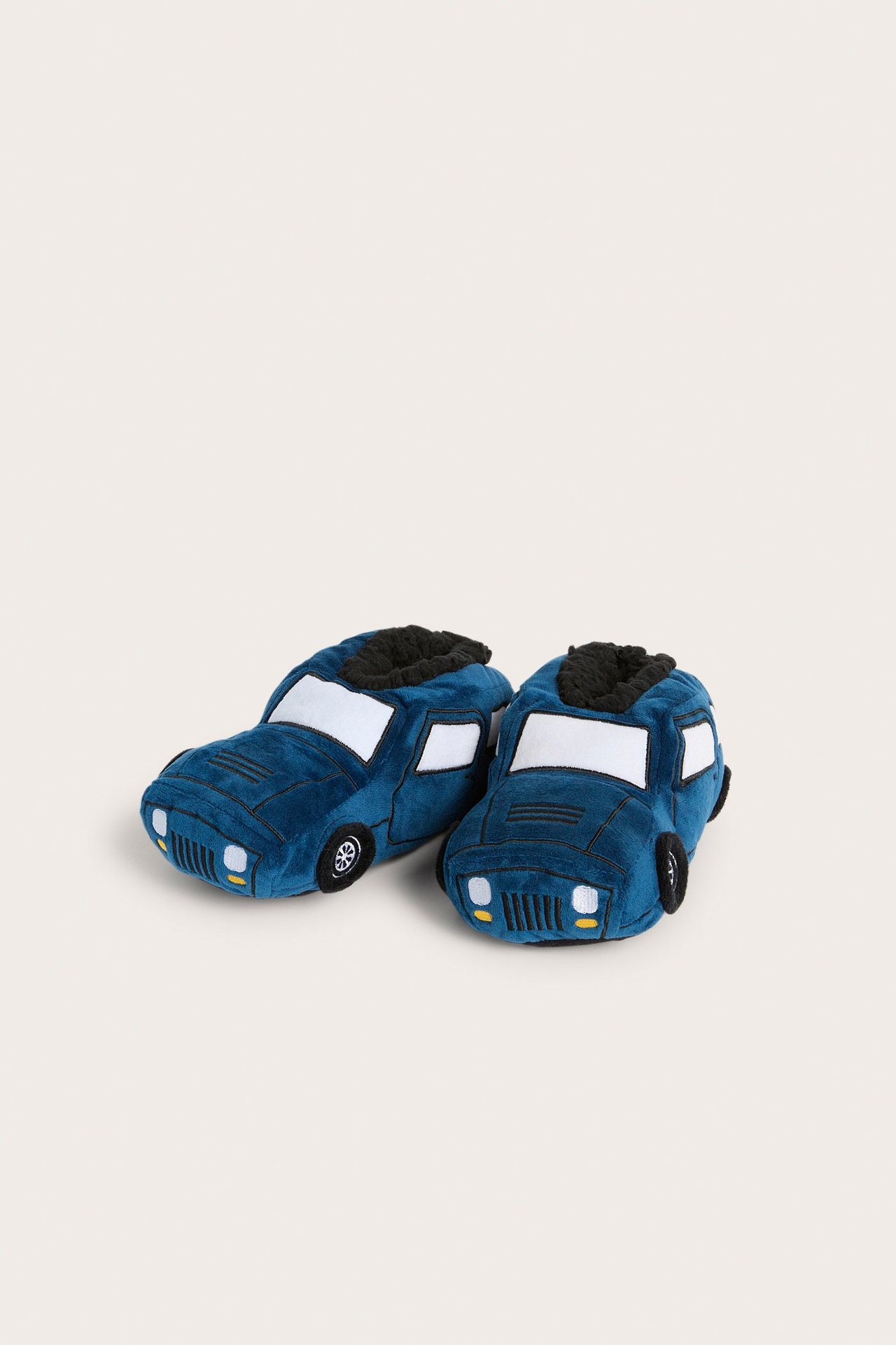 Edestäpäin: siniset lasten autotoffelit, joissa valkoiset ikkunat ja musta fleecevuori.