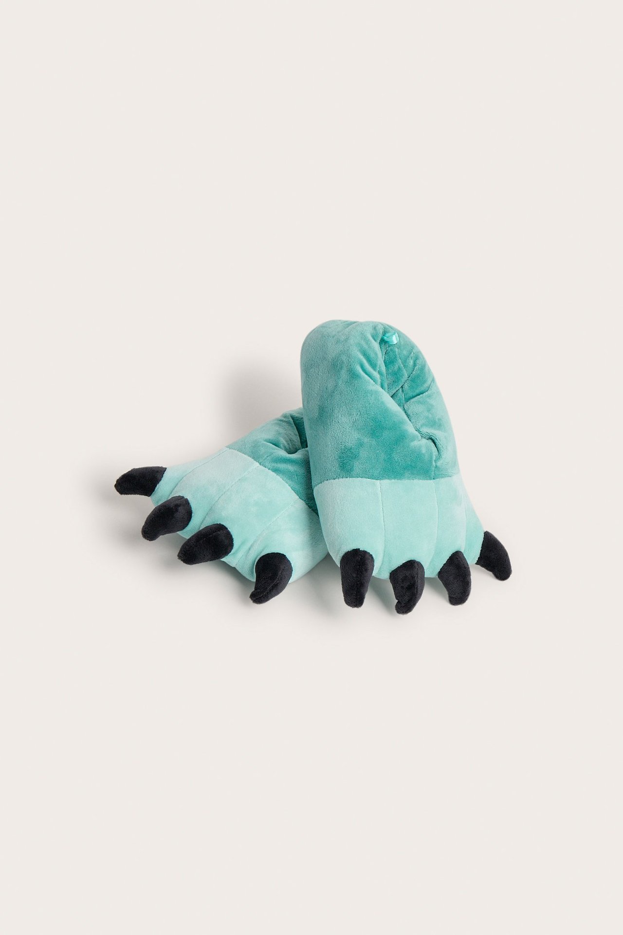 Edestä näkymä pehmeistä vaalean turkooseista kynsitossuista, joissa on mustat kynnet.