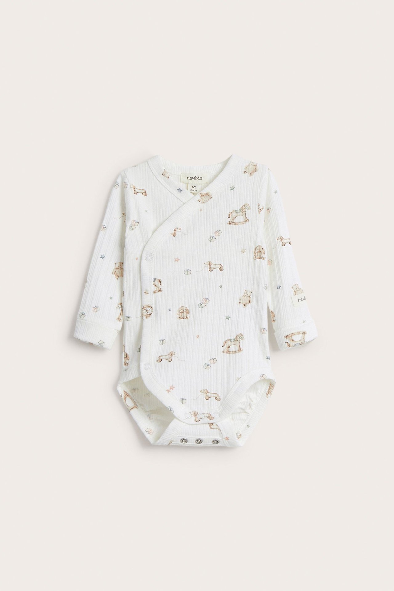 Frontvy av en offwhite långärmad omlottbody för baby med leksaksmönster och tryckknappar.