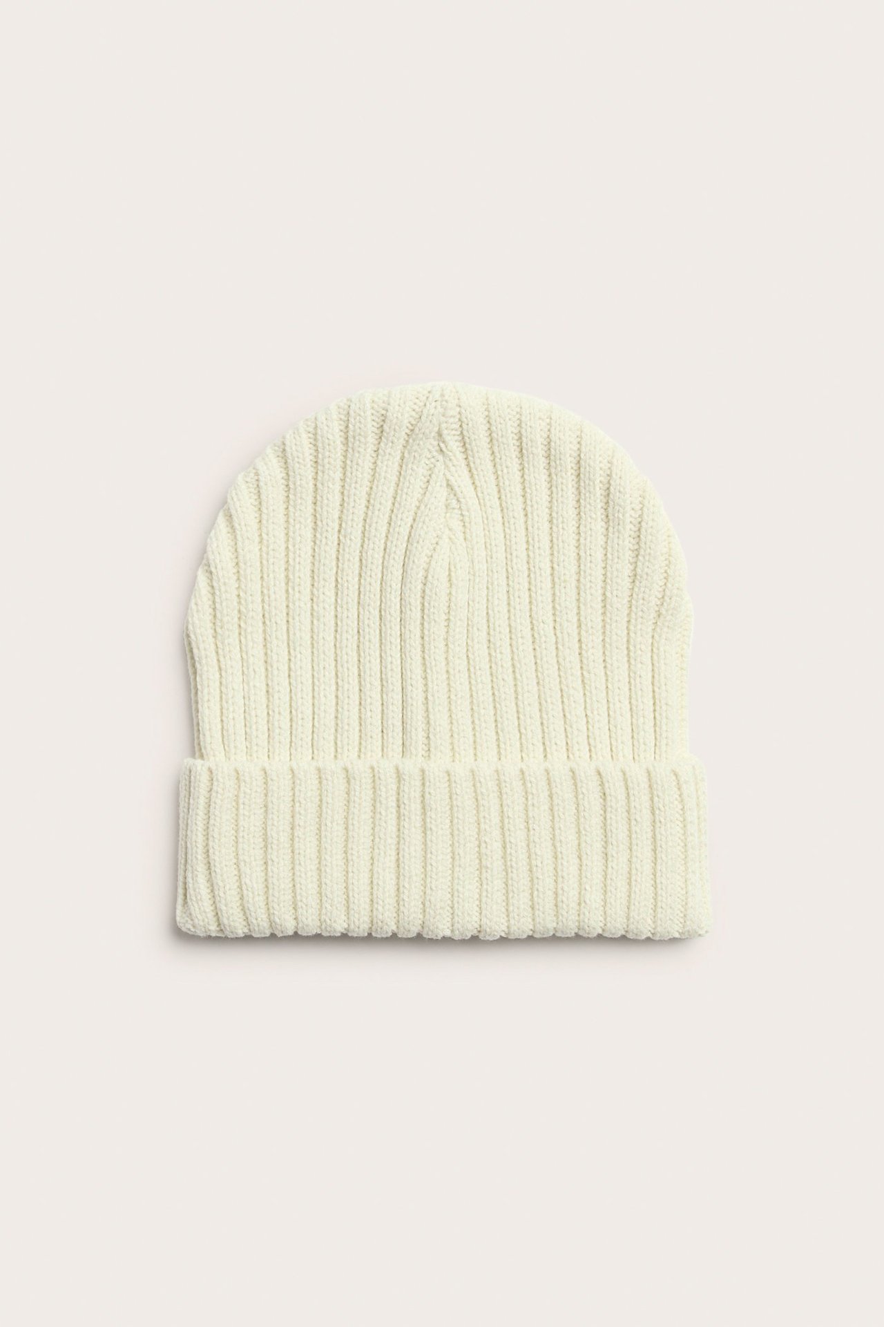Widok z przodu jasnobeżowej, prążkowanej czapki dzianinowej z szerokim wywinięciem.