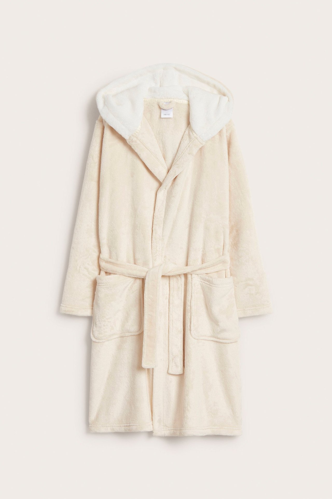 Frontvisning av en lys beige fleecerob med kremfôret hette, knytebelte og frontlommer.