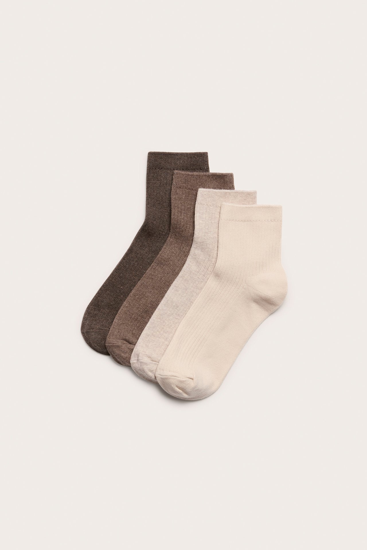 Ylhäältä kuvattuna neljä ribbineulottua nilkkasukkaa: tummanruskea, keskiruskea, vaalea melange ja beige.